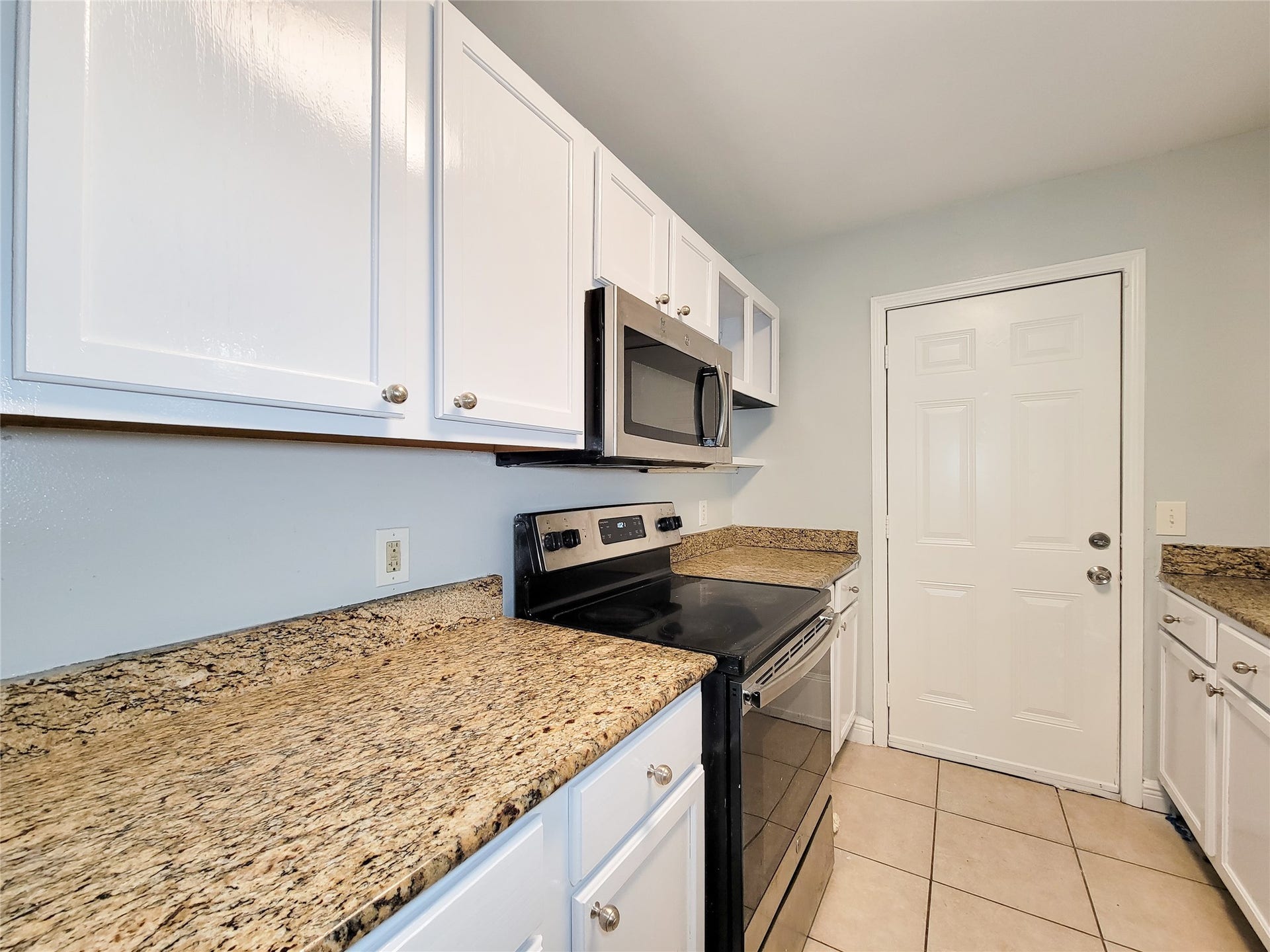 3005 La Estancia Lane, Houston, TX 77093 Modern kitchen with sleek granite countertops, stainless steel appliances, and crisp white cabinetry.