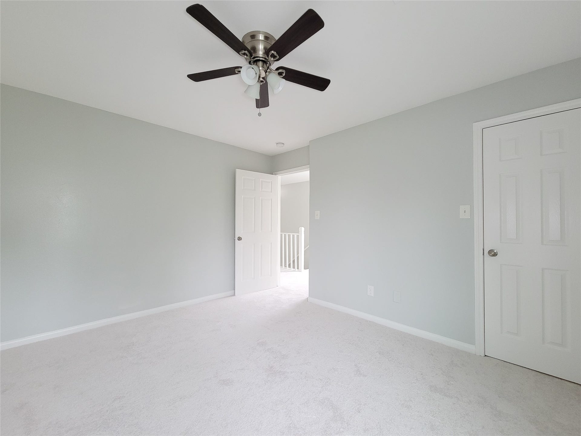 3005 La Estancia Lane, Houston, TX 77093 Bright and airy bedroom featuring soft gray walls, plush carpet, and a modern ceiling fan for comfort.