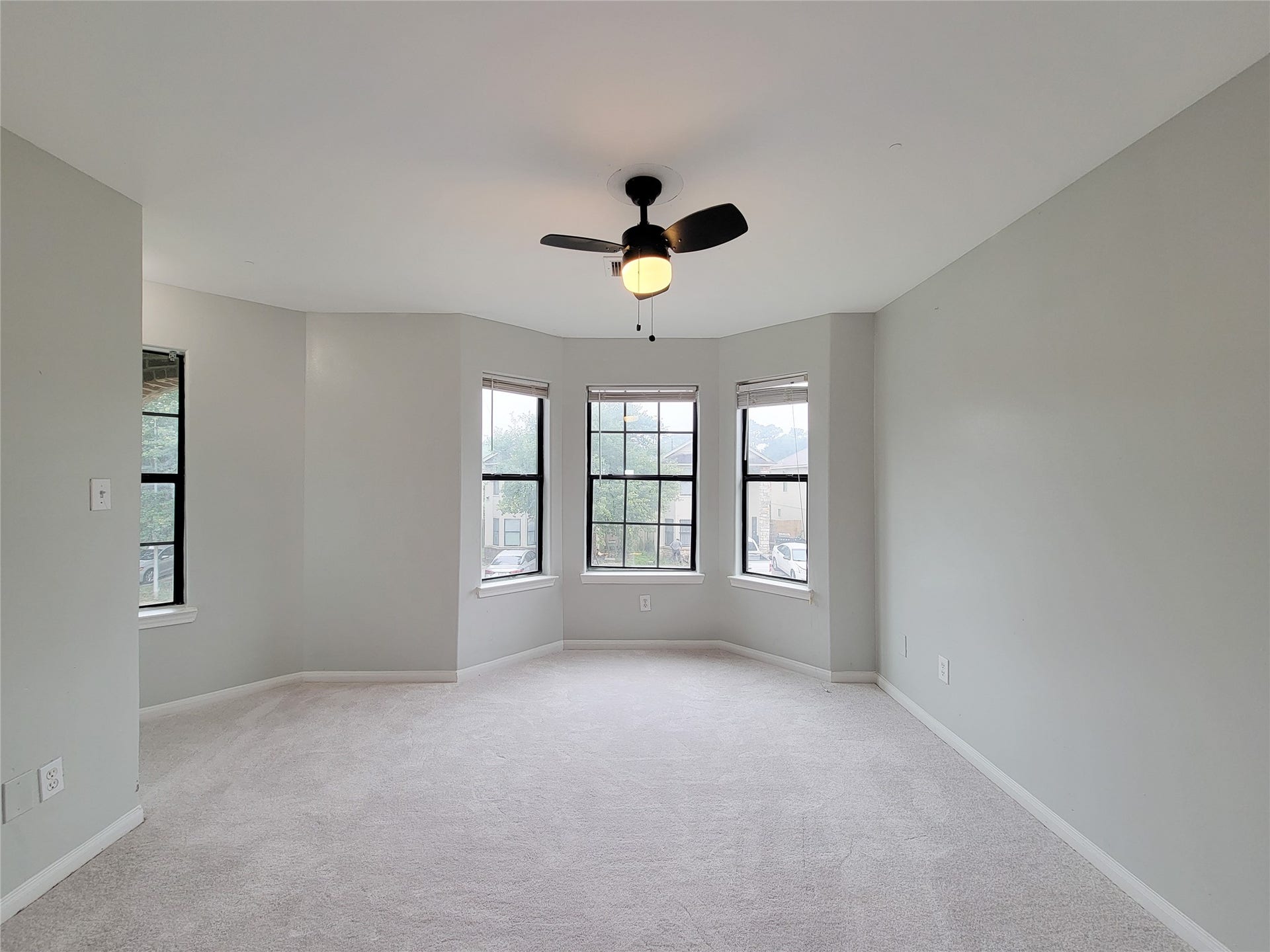 3005 La Estancia Lane, Houston, TX 77093 Bright and spacious room with a stylish ceiling fan, neutral walls, and abundant natural light pouring through multiple large windows.