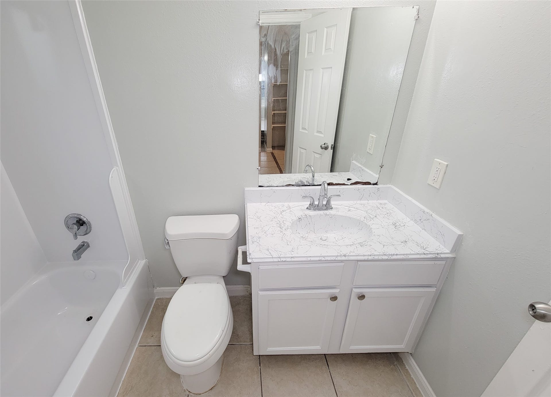 3005 La Estancia Lane, Houston, TX 77093 Modern bathroom with a sleek white vanity and marble-style countertop, featuring a spacious mirror and a clean bathtub-shower combo.