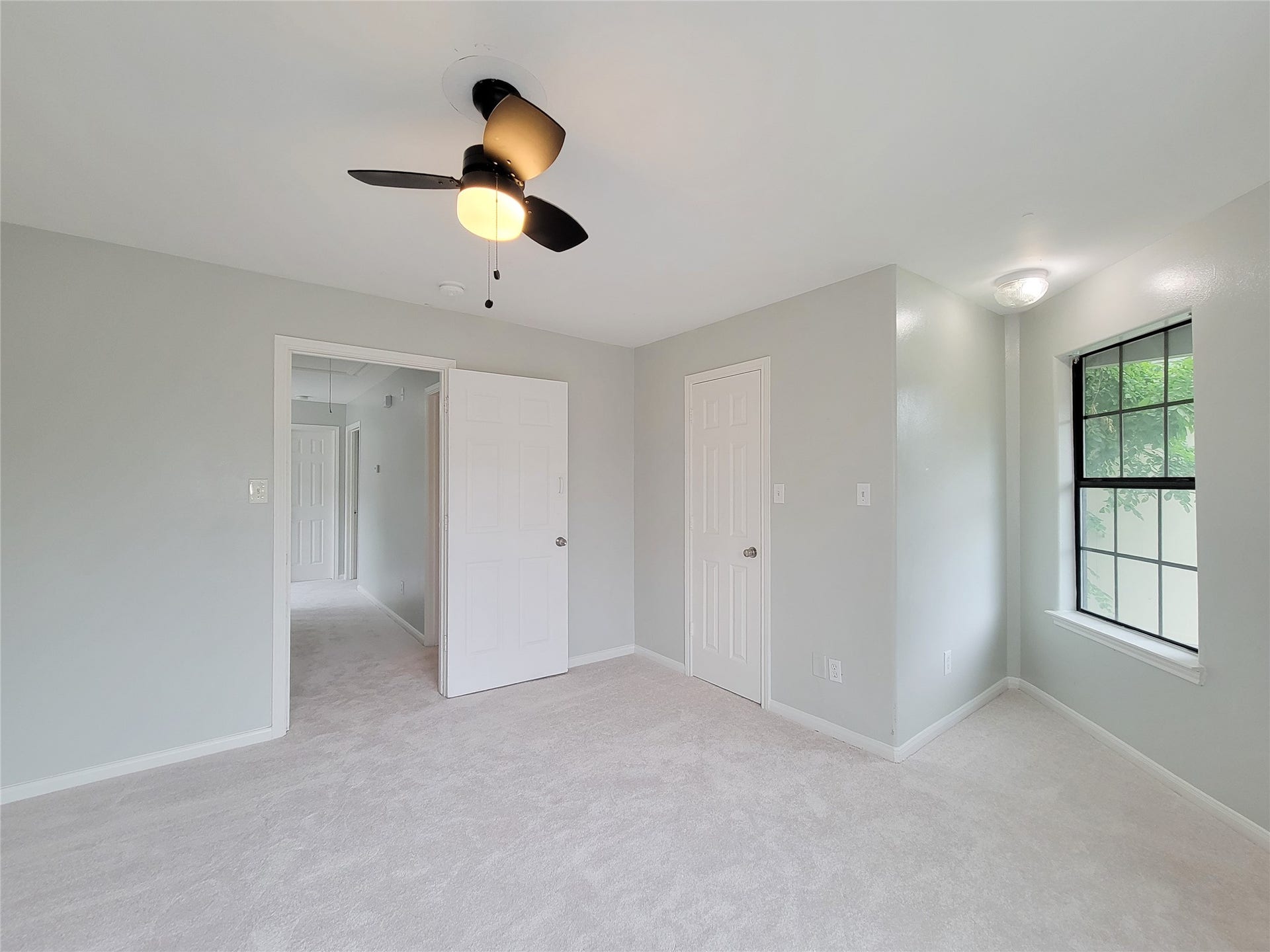 3005 La Estancia Lane, Houston, TX 77093 Bright and airy bedroom featuring soft carpeting, neutral walls, a ceiling fan, and a large window that invites natural light.