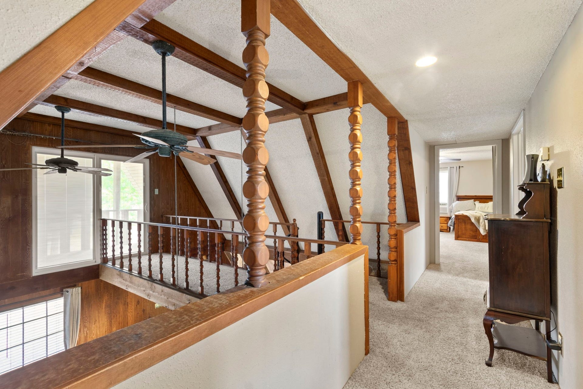 Step onto the upstairs walkway leading to the outdoor balcony.
The open doorway ahead welcomes you into one of two generously sized upstairs bedrooms.