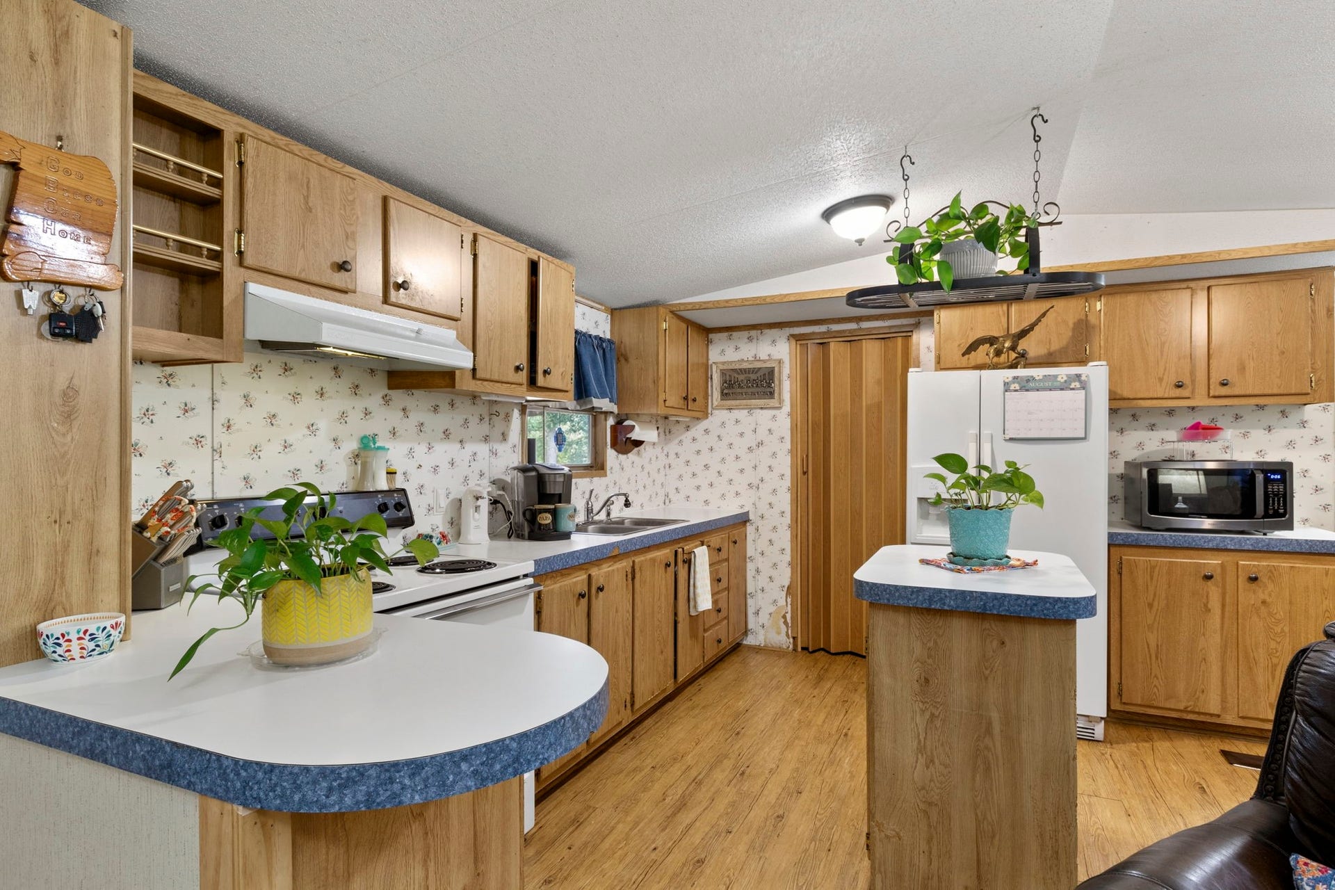 The light and bright island kitchen offers plenty of storage, with a convenient indoor utility room located just beyond the kitchen.