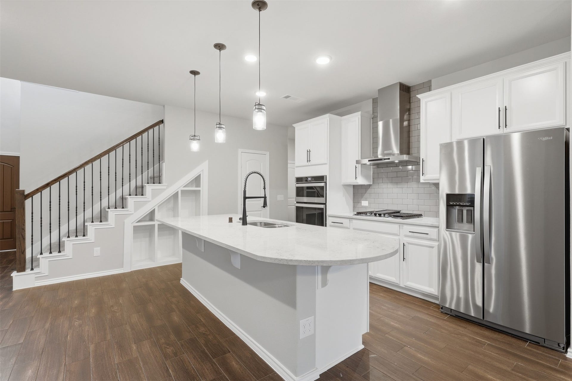 4028 Starbright Street, Houston, TX 77018 This angle showcases custom built-in shelving tucked neatly beneath the staircase, maximizing storage space next to the kitchen island.