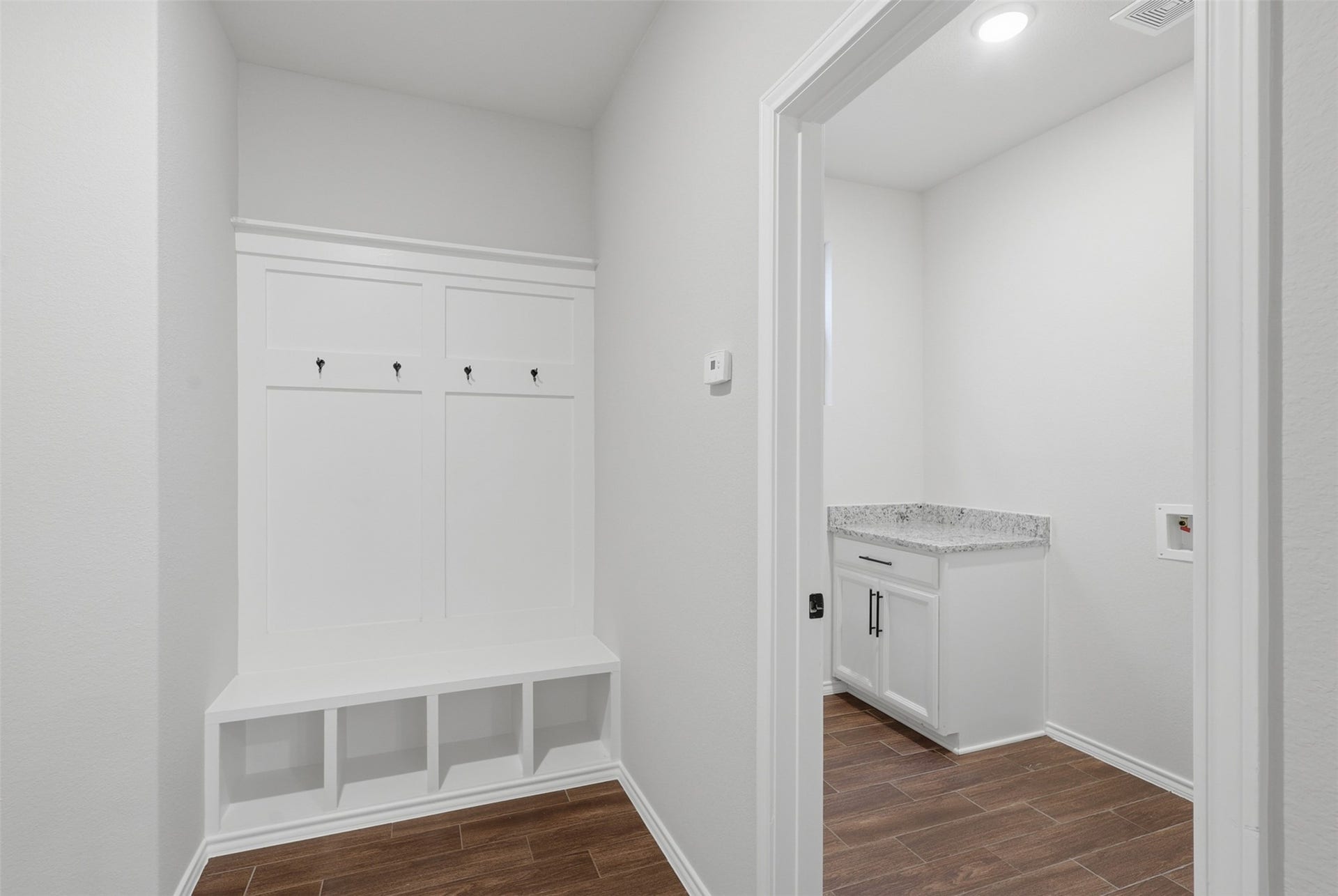 4028 Starbright Street, Houston, TX 77018 Functional entryway with wood-look tile flooring, built-in mudroom bench with storage cubbies and coat hooks, plus an adjacent laundry area.