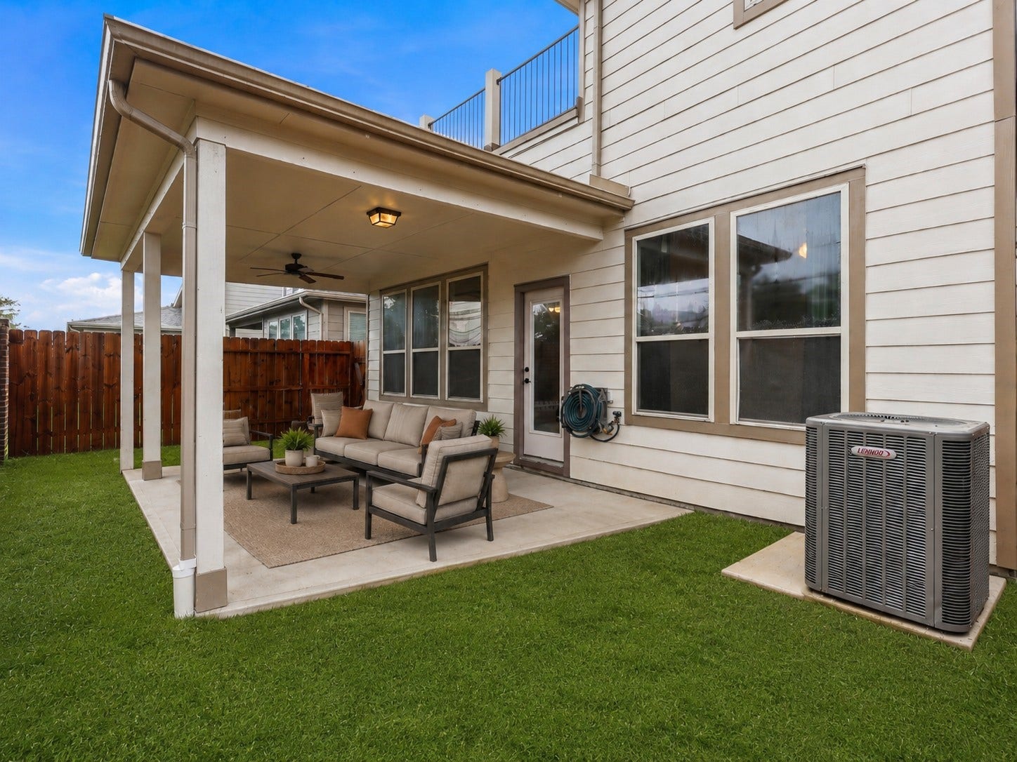 4028 Starbright Street, Houston, TX 77018 The exterior features a covered patio seamlessly built into the homes siding, accented by functional gutter downspouts and a nearby HVAC system for added utility.**Virtually staged