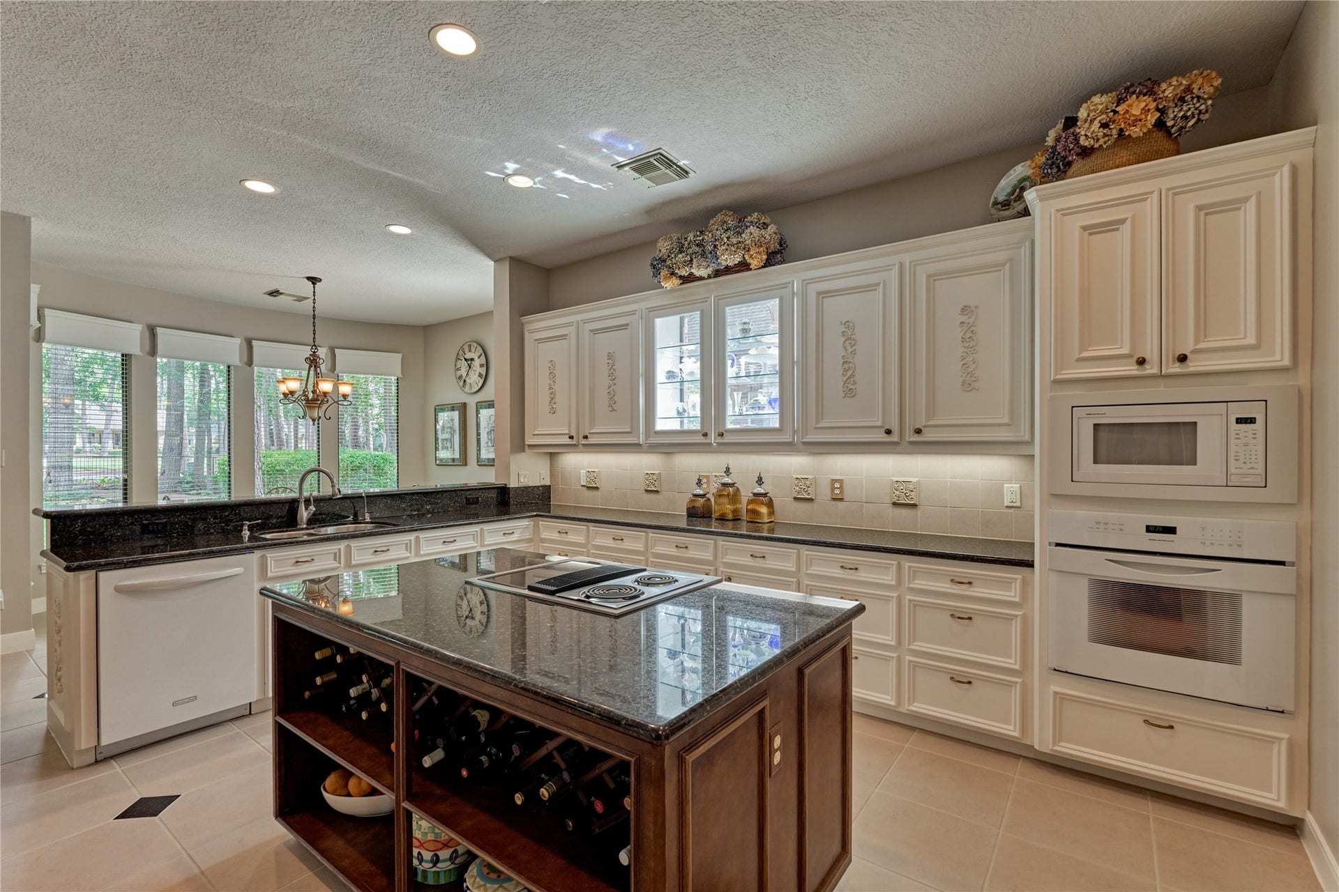 3073 Bentwater Drive, Montgomery, TX 77356 The center island houses a cooktop/oven and also has built-in wine storage. The second oven is built into the wall just below the microwave.