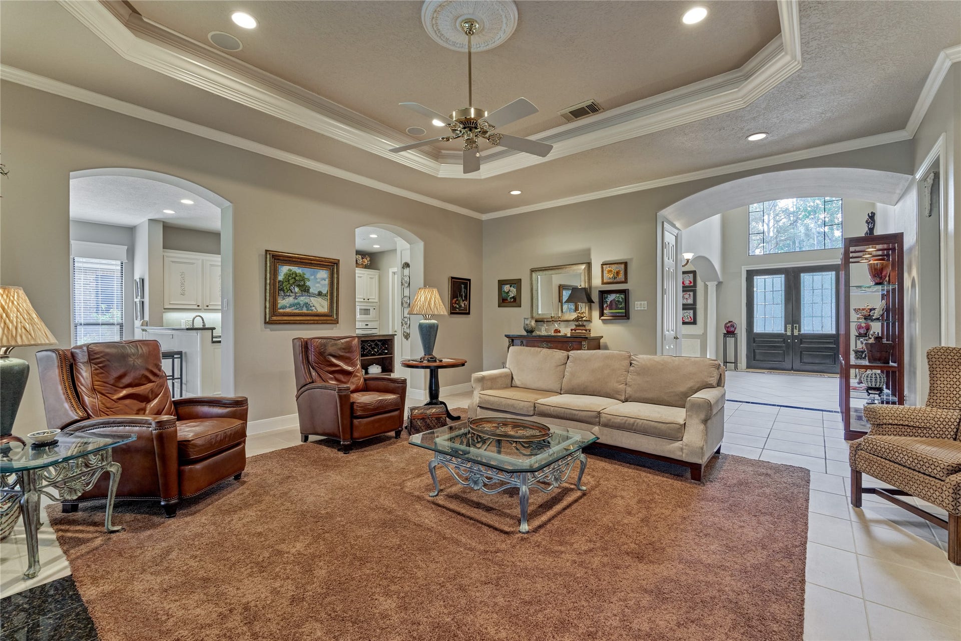 3073 Bentwater Drive, Montgomery, TX 77356 The inviting living room enjoys a warm fireplace and overlooks the backyard. The recessed ceiling provides a sophisticated aesthetic and elegantly illuminates the space.