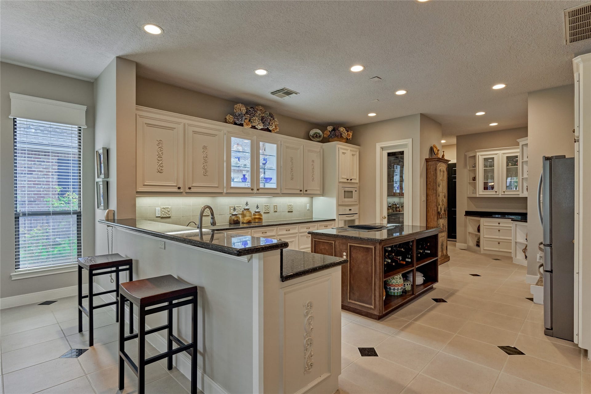 3073 Bentwater Drive, Montgomery, TX 77356 The elegantly appointed kitchen boasts of custom cabinetry featuring lighted glass uppers and a butler's pantry.