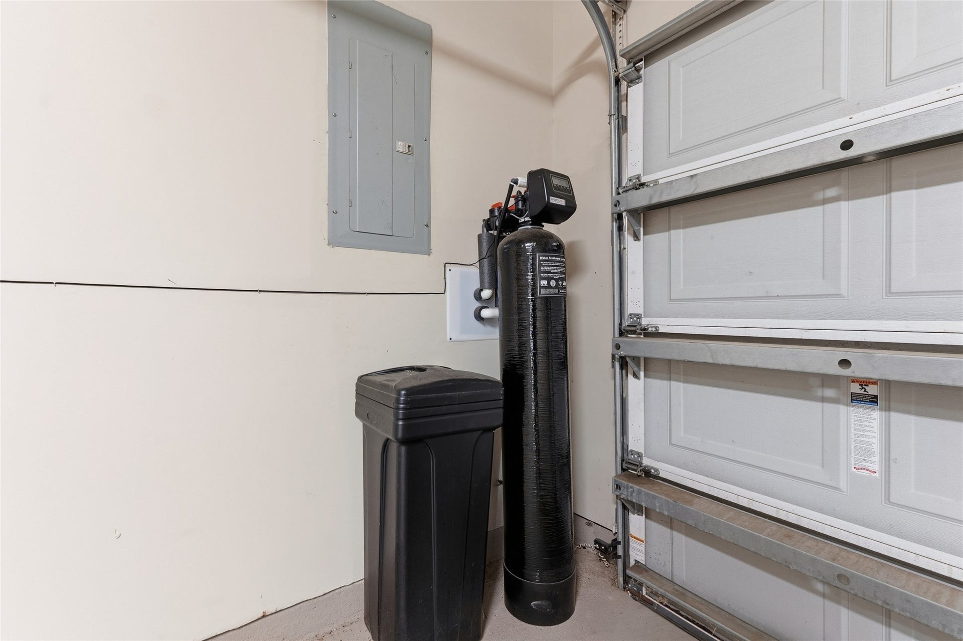A well-organized garage corner featuring a water softener system, ensuring quality water throughout the home.