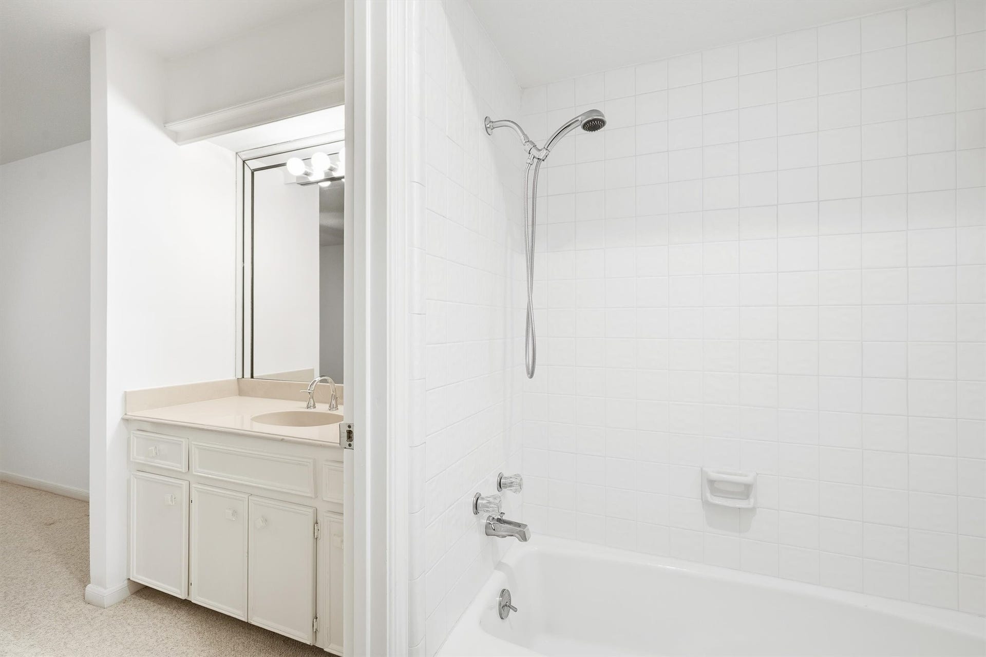 12219 Ravenmoor Drive, Houston, TX 77077 Bright bathroom with a sleek white tile shower and a practical vanity with ample storage, perfect for modern living.