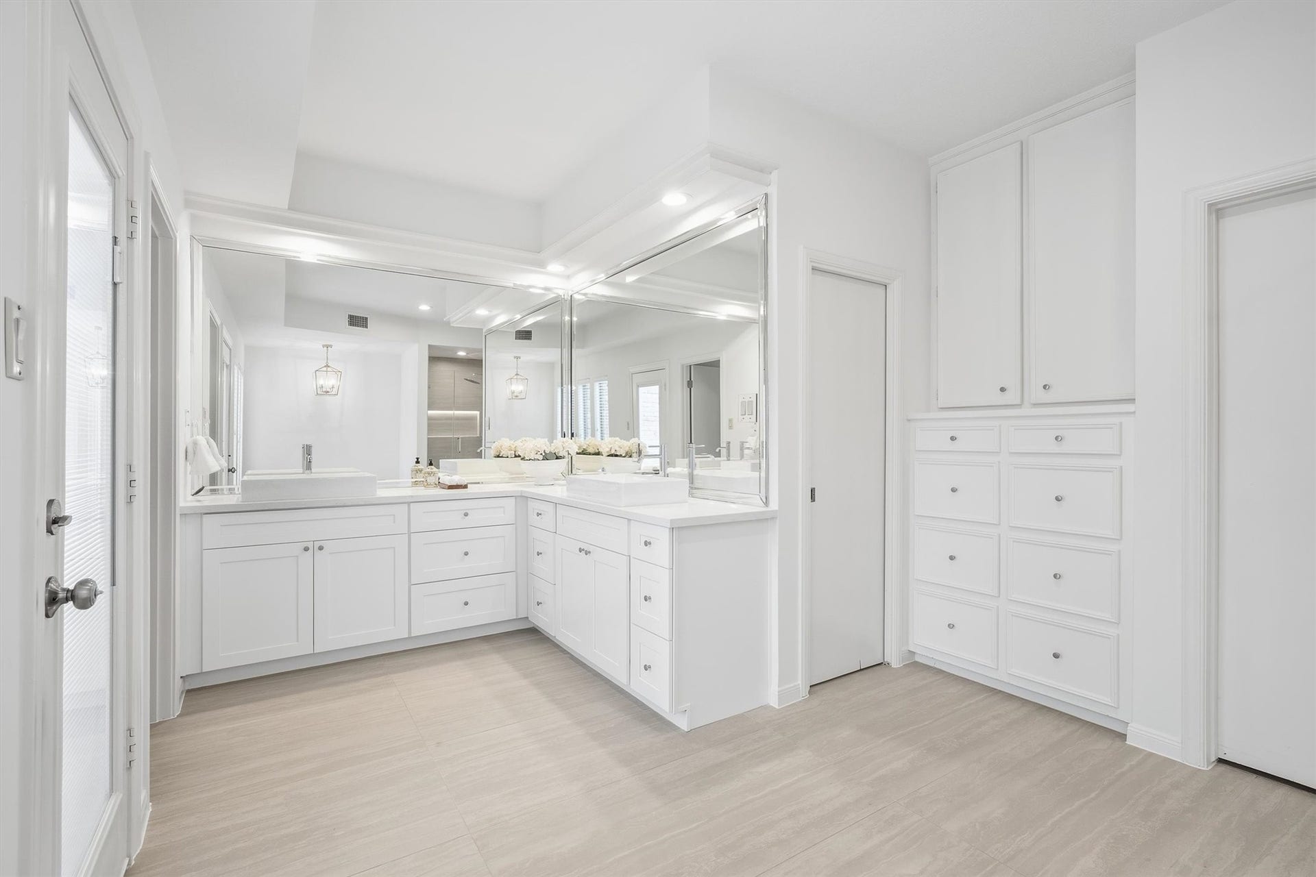 12219 Ravenmoor Drive, Houston, TX 77077 Spacious and elegant bathroom featuring sleek white cabinetry, ample storage, and a large mirror enhancing the bright, airy feel.