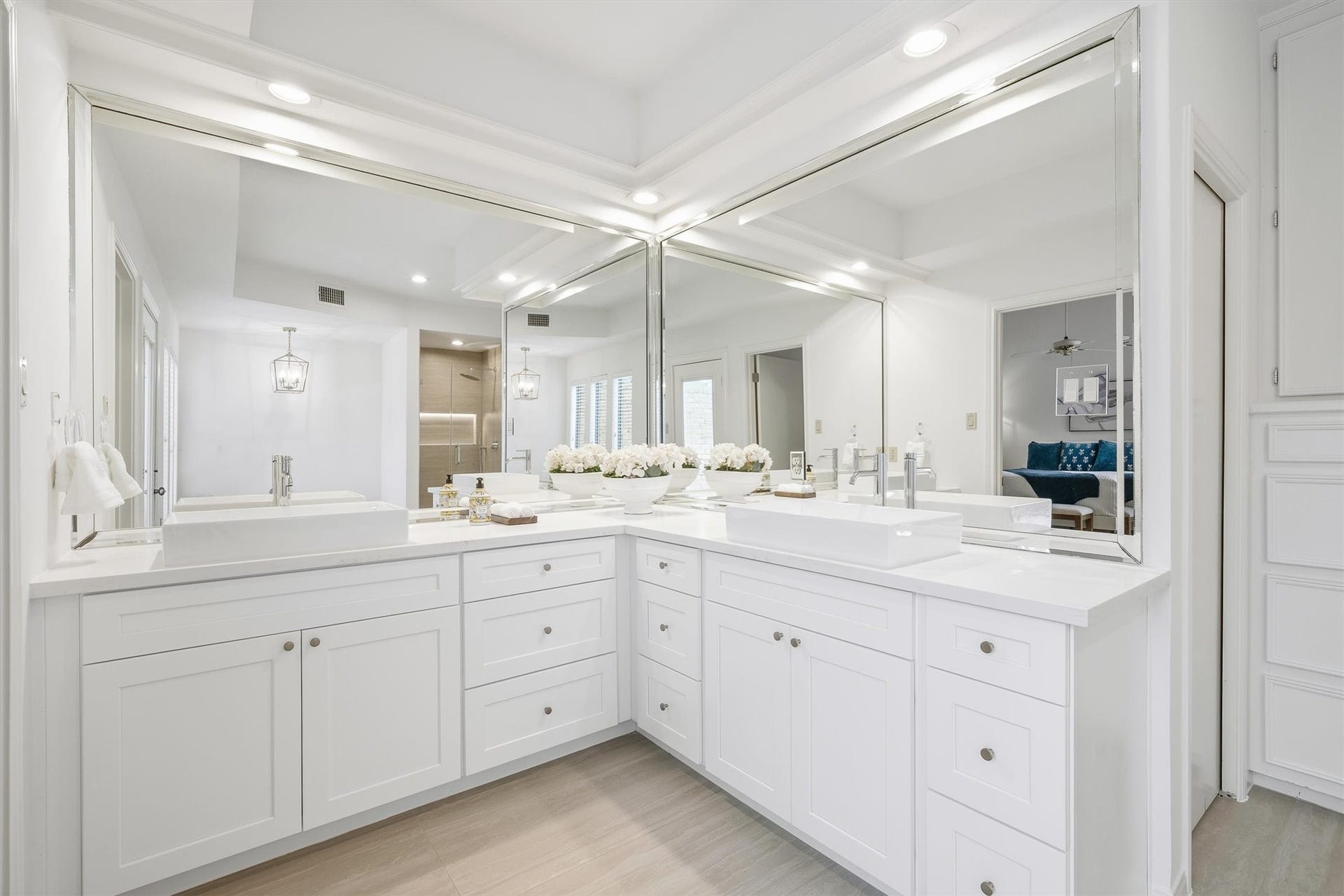12219 Ravenmoor Drive, Houston, TX 77077 Luxurious bathroom featuring an expansive double vanity with elegant white cabinetry, sleek countertops, and large mirrors, creating a bright and inviting space.