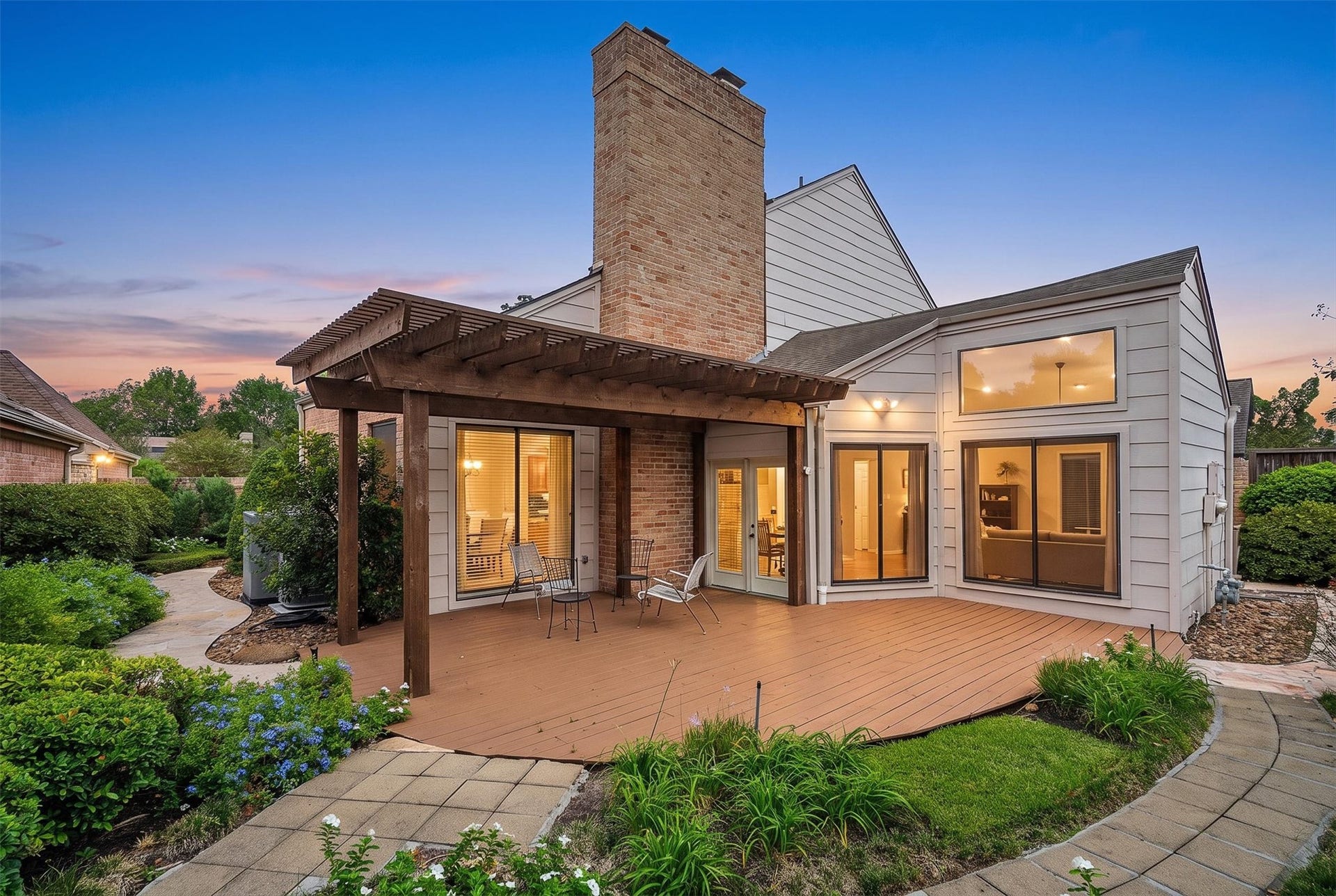 12219 Ravenmoor Drive, Houston, TX 77077 Charming home with a spacious wooden deck and pergola, perfect for outdoor relaxation, surrounded by lush greenery and a beautifully landscaped garden.