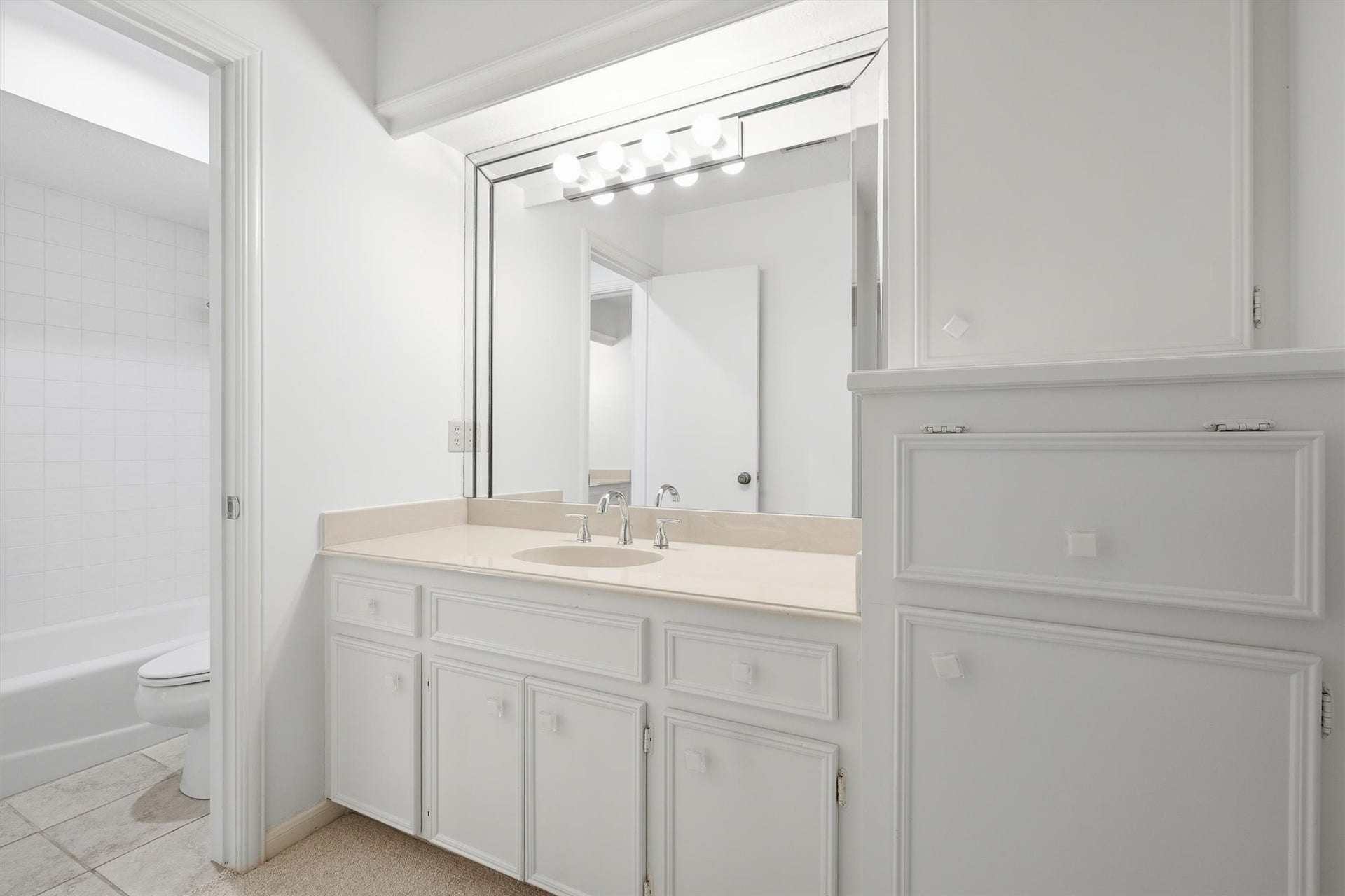 12219 Ravenmoor Drive, Houston, TX 77077 Bright and clean bathroom featuring a spacious vanity with ample storage, a large mirror with modern lighting, and a convenient tub-shower combo.