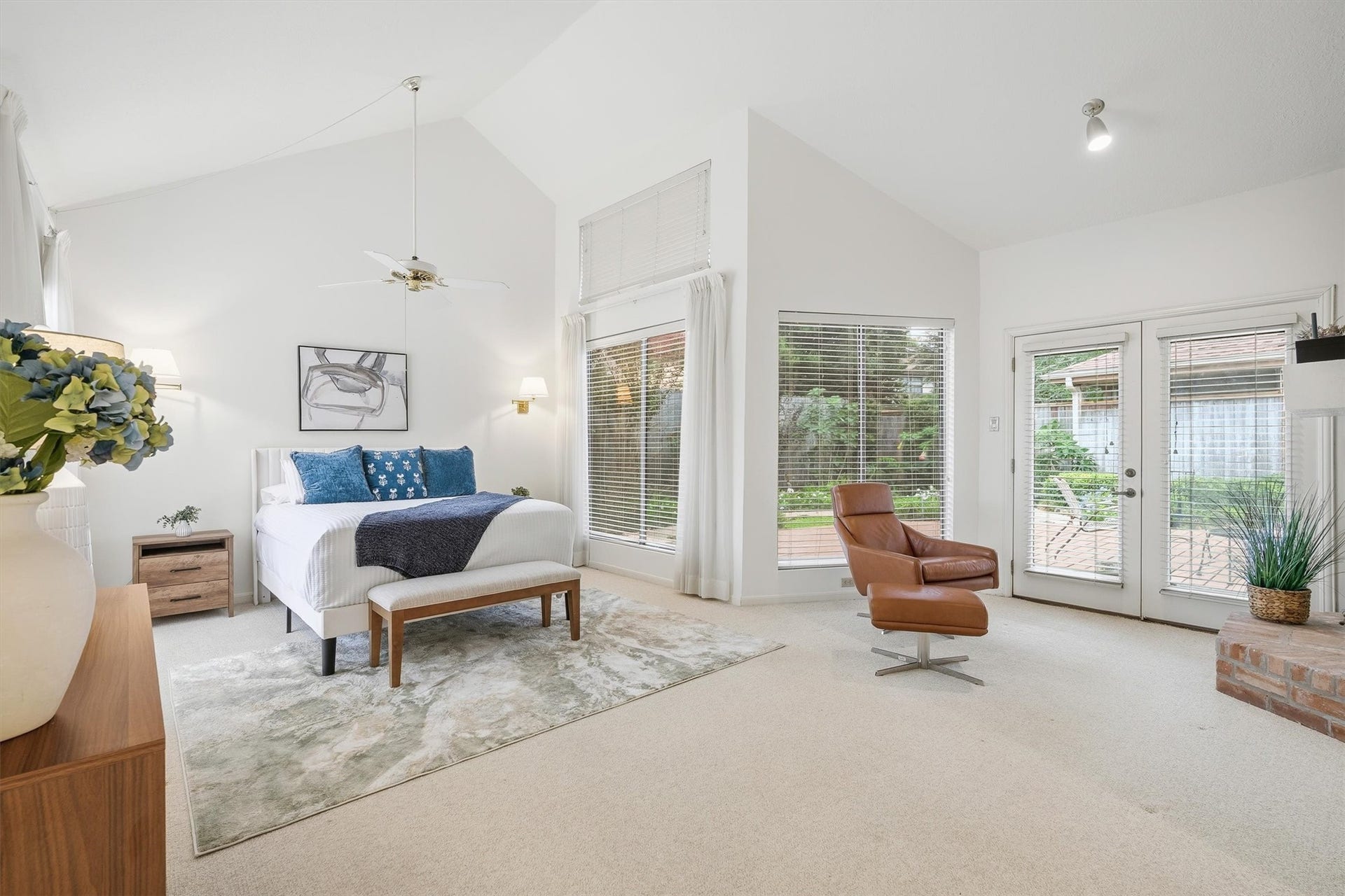 12219 Ravenmoor Drive, Houston, TX 77077 Spacious and bright primary bedroom with high ceilings, featuring large windows and French doors that open to a serene outdoor space.