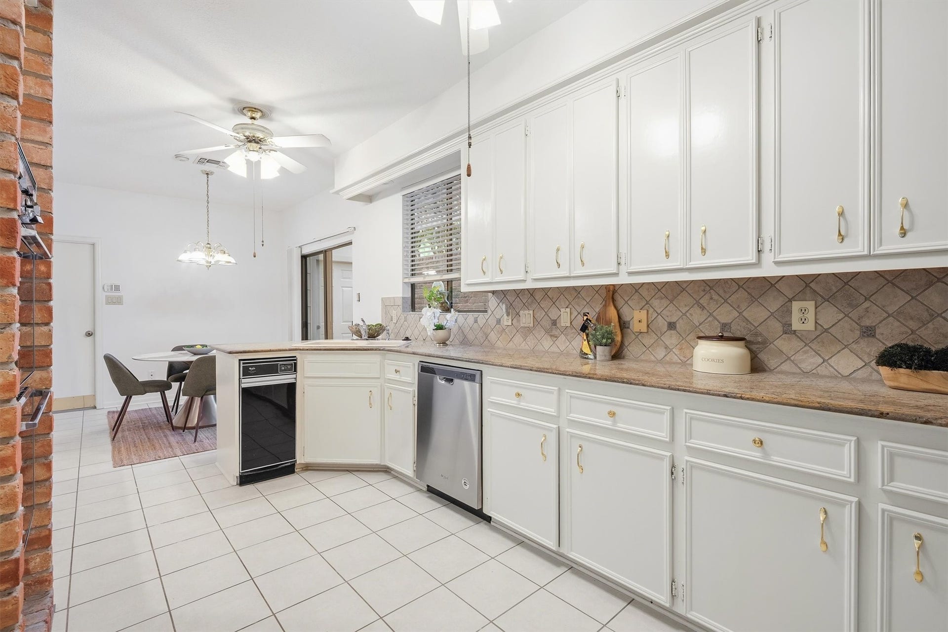 12219 Ravenmoor Drive, Houston, TX 77077 Spacious kitchen with elegant white cabinetry, modern appliances, and a cozy dining area, perfect for family gatherings.