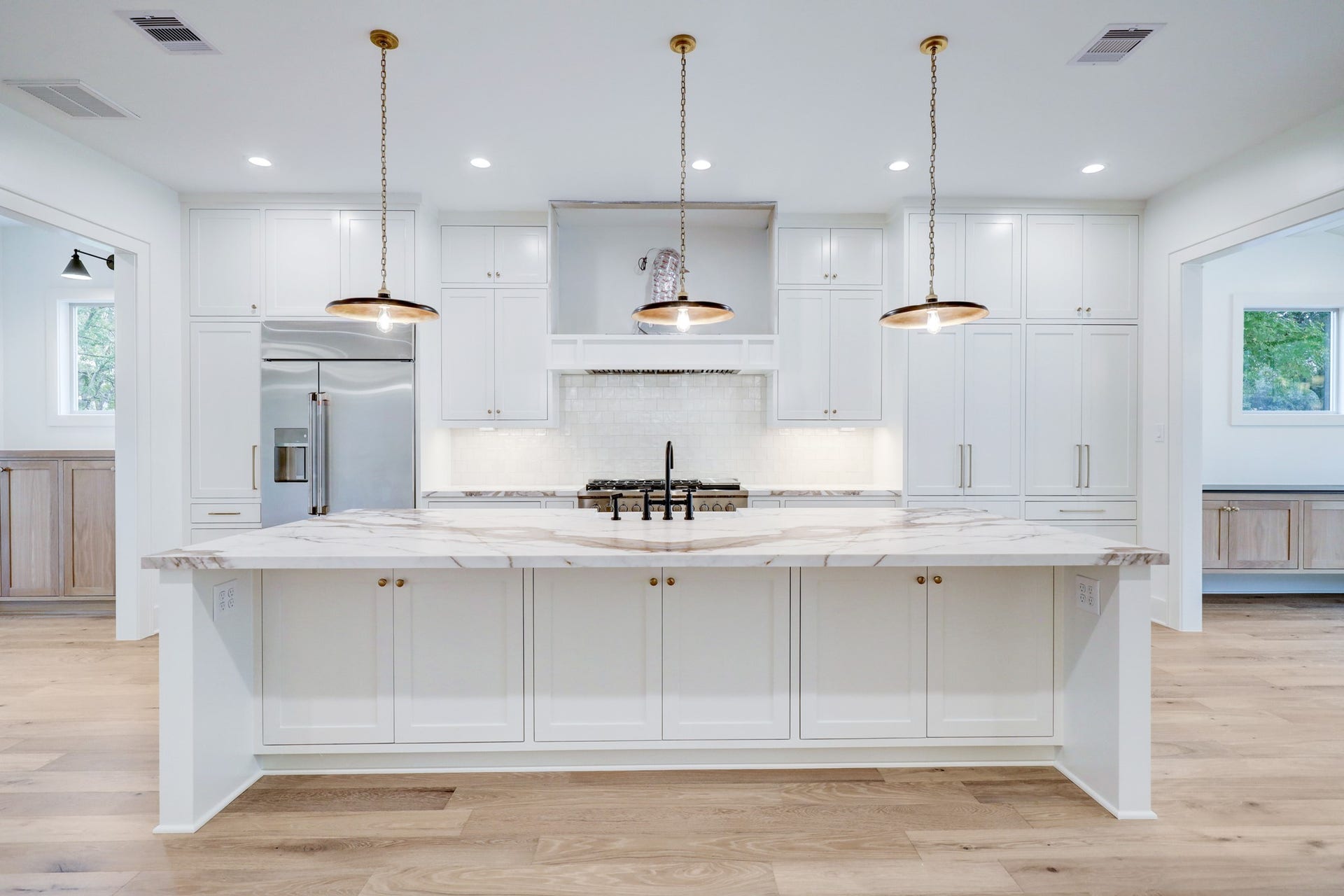 The kitchen boasts desirable amenities with floor to ceiling cabinetry & storage, white subway tile backsplash, sleek stainless appliances and a large island with additional storage and seating. *Previous Project*