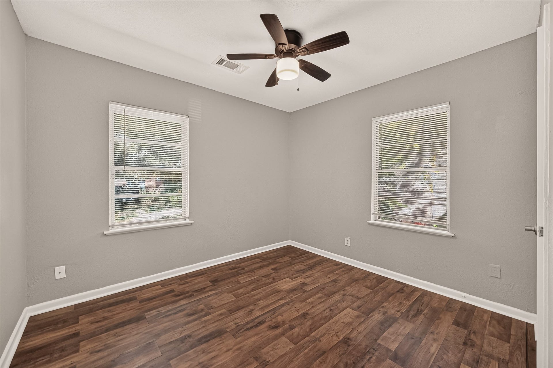 5935 Beldart Street, Houston, TX 77033 Bedroom 2, unfurnished, with windows on two walls and ceiling fan.