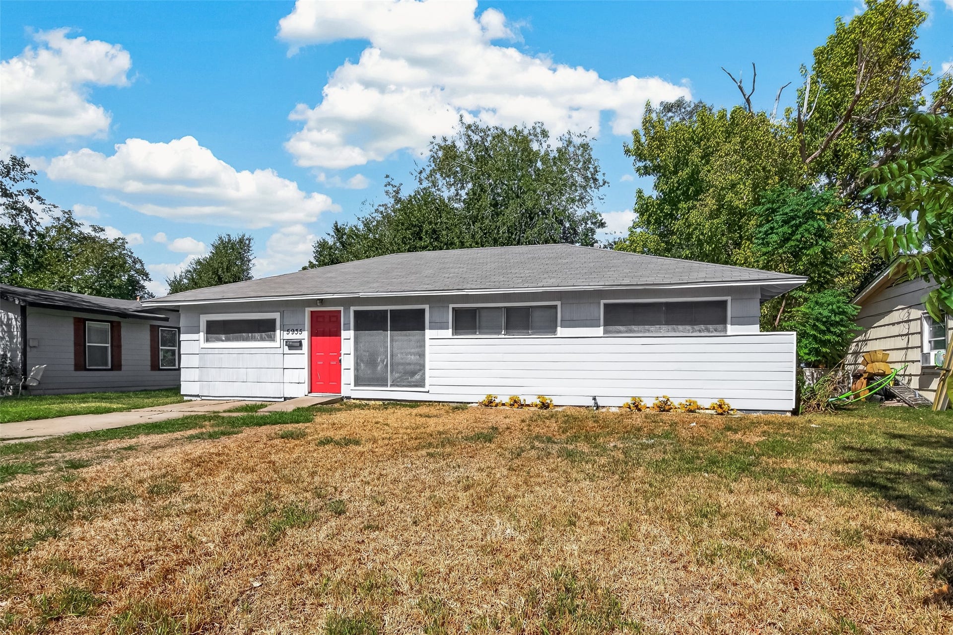 5935 Beldart Street, Houston, TX 77033 Front exterior: single-story home with red front door and mature trees.