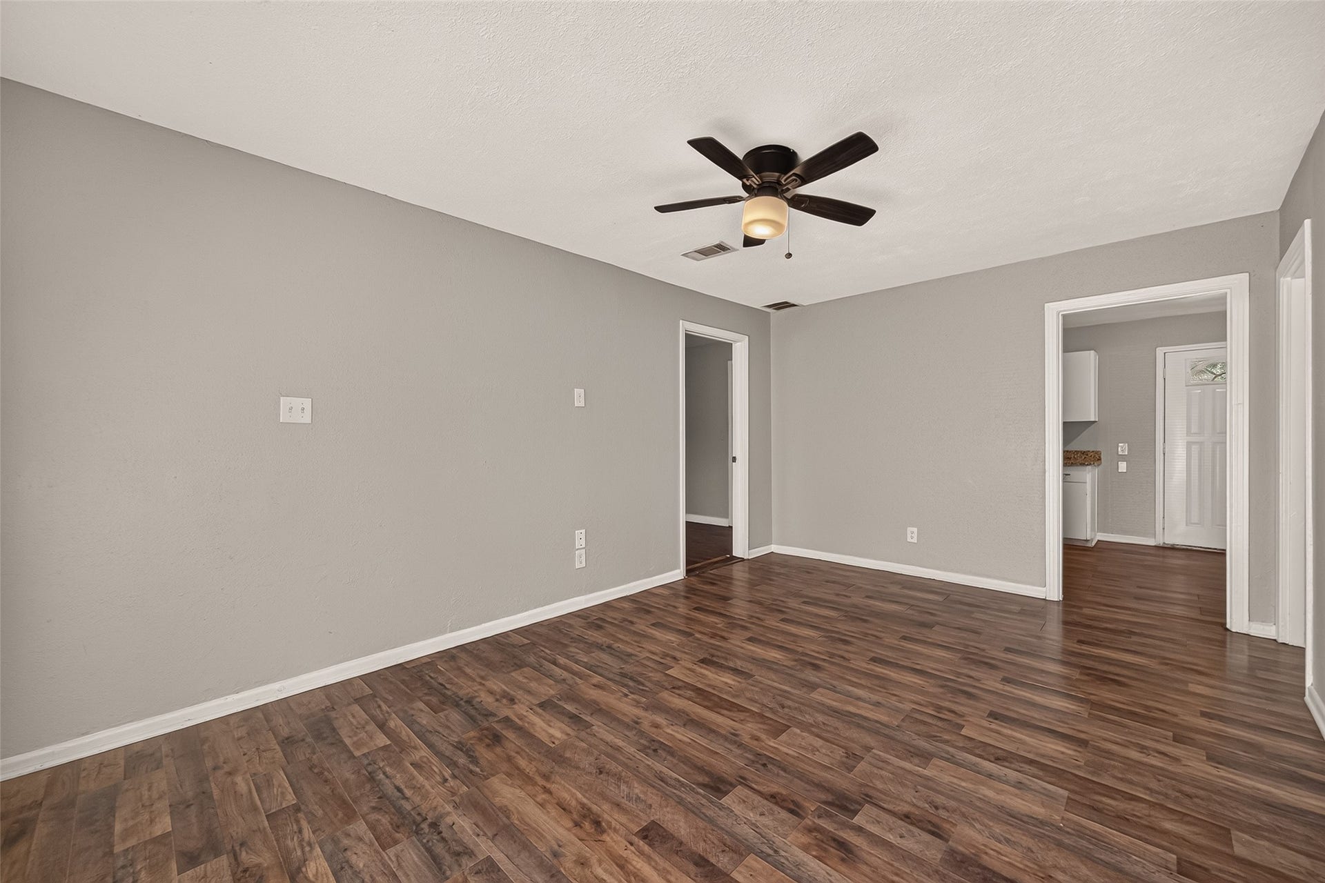 5935 Beldart Street, Houston, TX 77033 Living room, unfurnished, open to the kitchen and hallway.