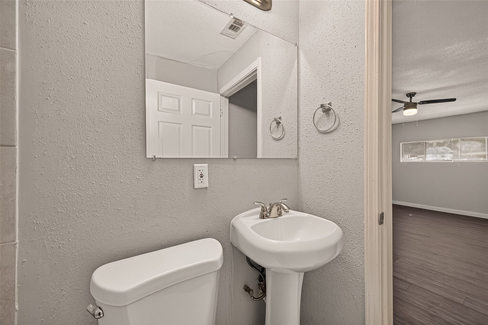 5935 Beldart Street, Houston, TX 77033 Primary en-suite bath with tile flooring and pedestal sink, open to the primary bedroom.