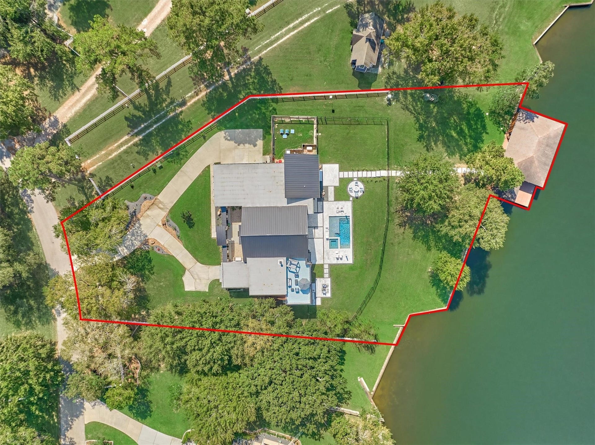 9228 Lake Conroe Drive, Conroe, TX 77304 A bird's eye view reveals the expansive yard on a full acre with both fenced and unfenced areas along with stunning 180 degree views of Lake Conroe.