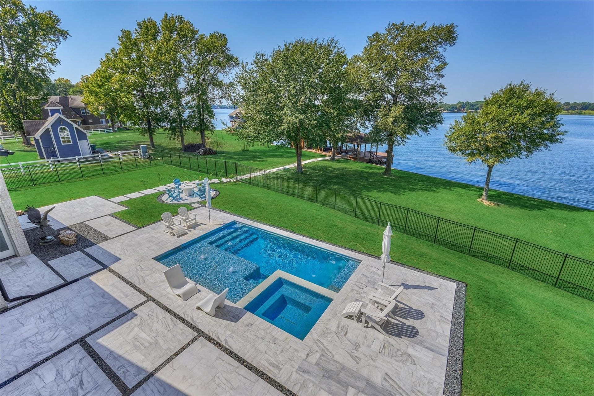 9228 Lake Conroe Drive, Conroe, TX 77304 42. The view from the roof deck offers a stunning perspective of the pool and yard area. The expansive marble pool surround creates ample space for entertaining.
