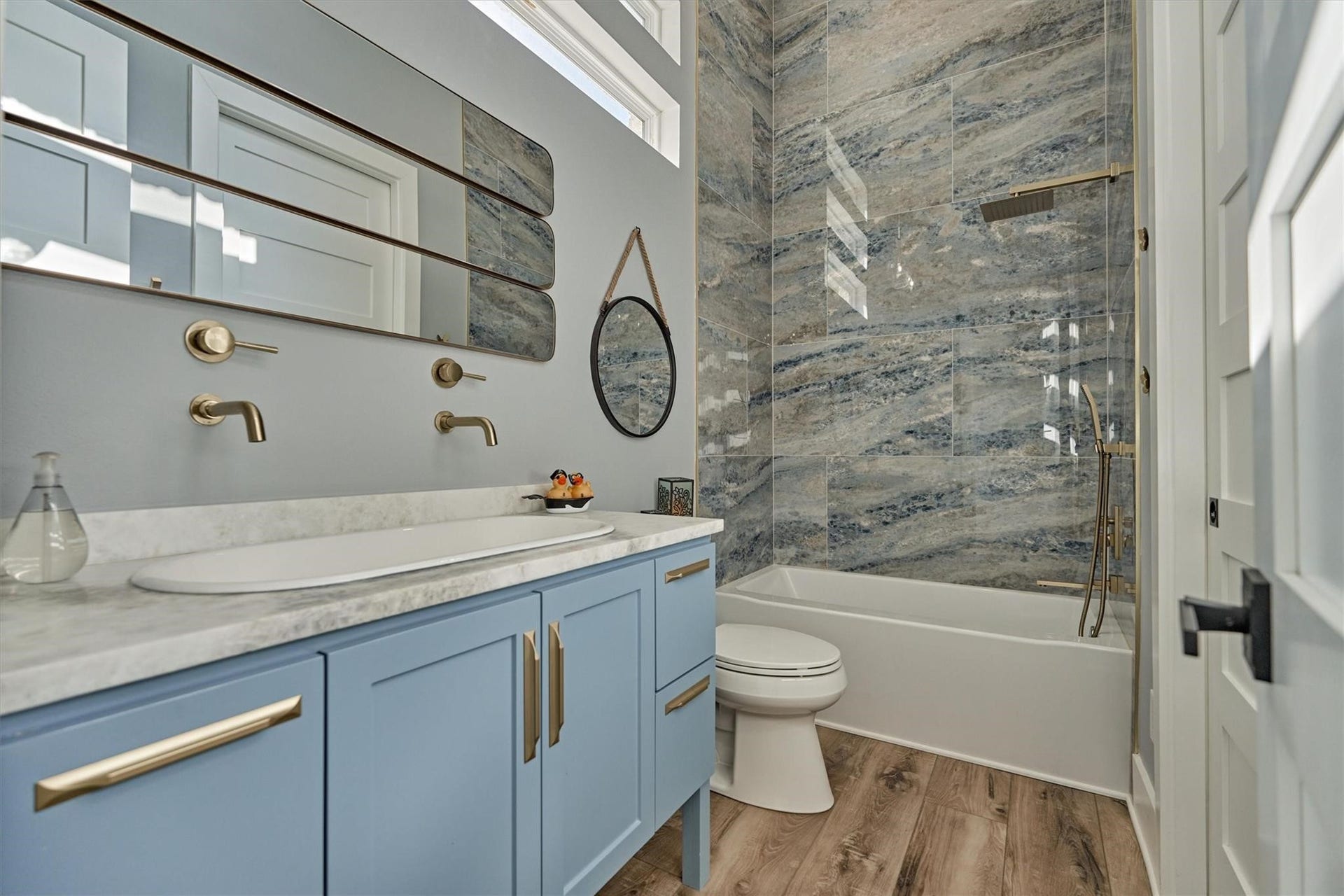 9228 Lake Conroe Drive, Conroe, TX 77304 40. This full bath features stunning porcelain walls and a coordinating vanity creating a luxurious and cohesive look. High rectangular windows allows natural light to fill the space while maintaining privacy, adding both brightness and elegance.