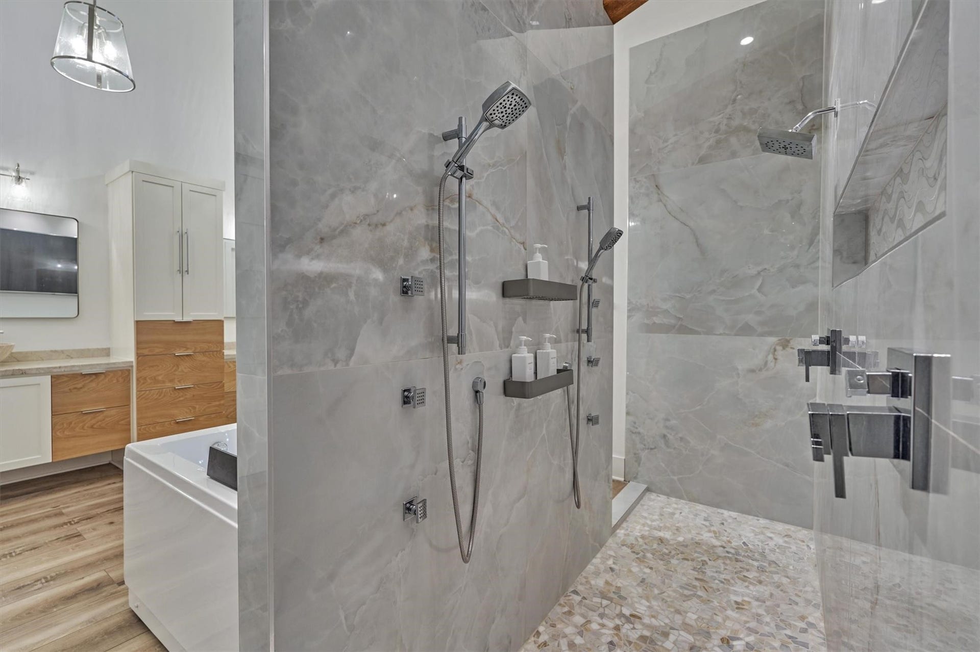 9228 Lake Conroe Drive, Conroe, TX 77304 The walk through shower is elegantly trimmed in marble and features multiple shower heads and comfortable pebble flooring.