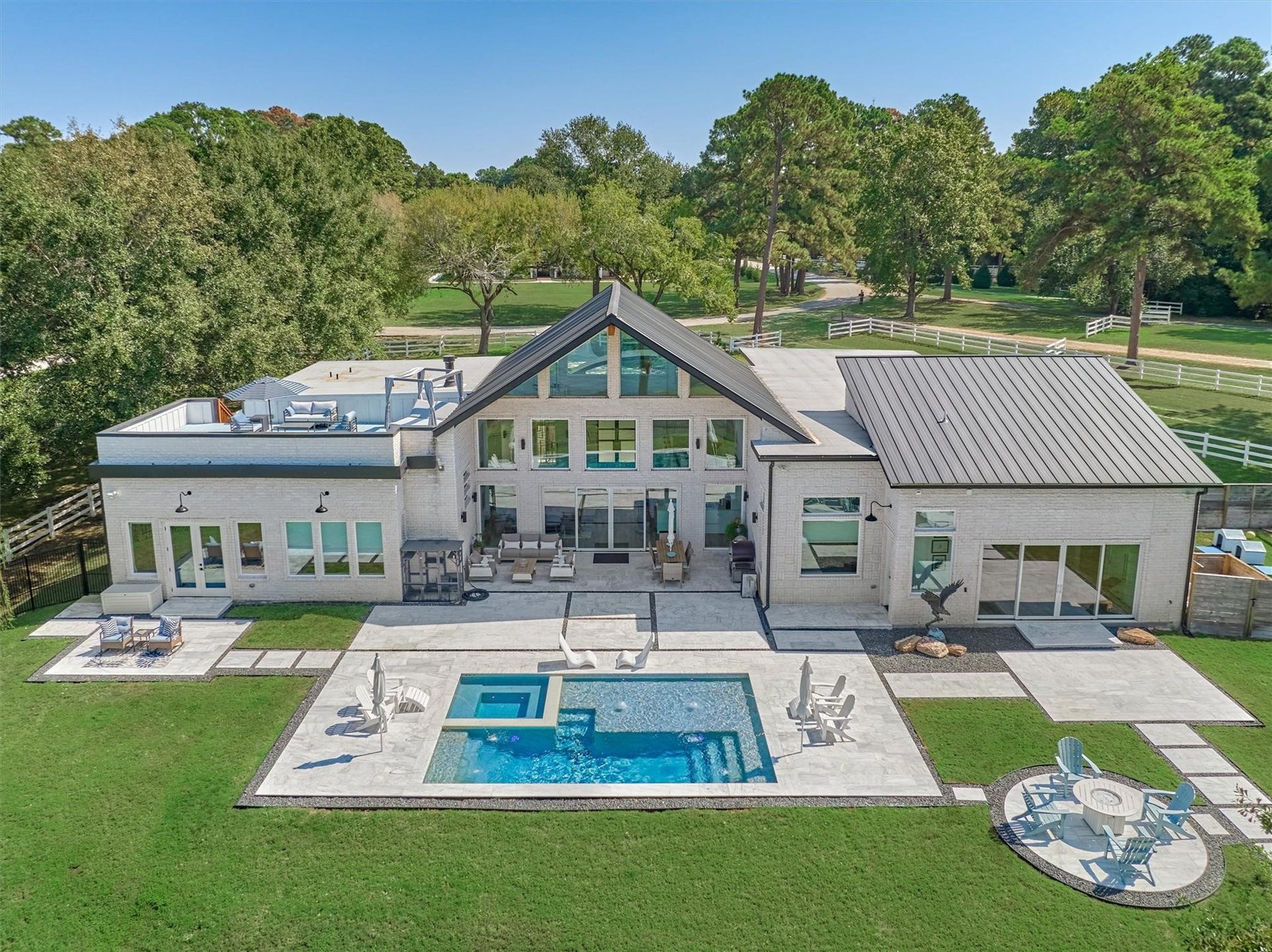 9228 Lake Conroe Drive, Conroe, TX 77304 A rear view of the home showcases a heated chlorine pool and hot tub. The 1" thick marble pool surround stays cool to the touch, even on the hottest days, ensuring comfort for bare feet.