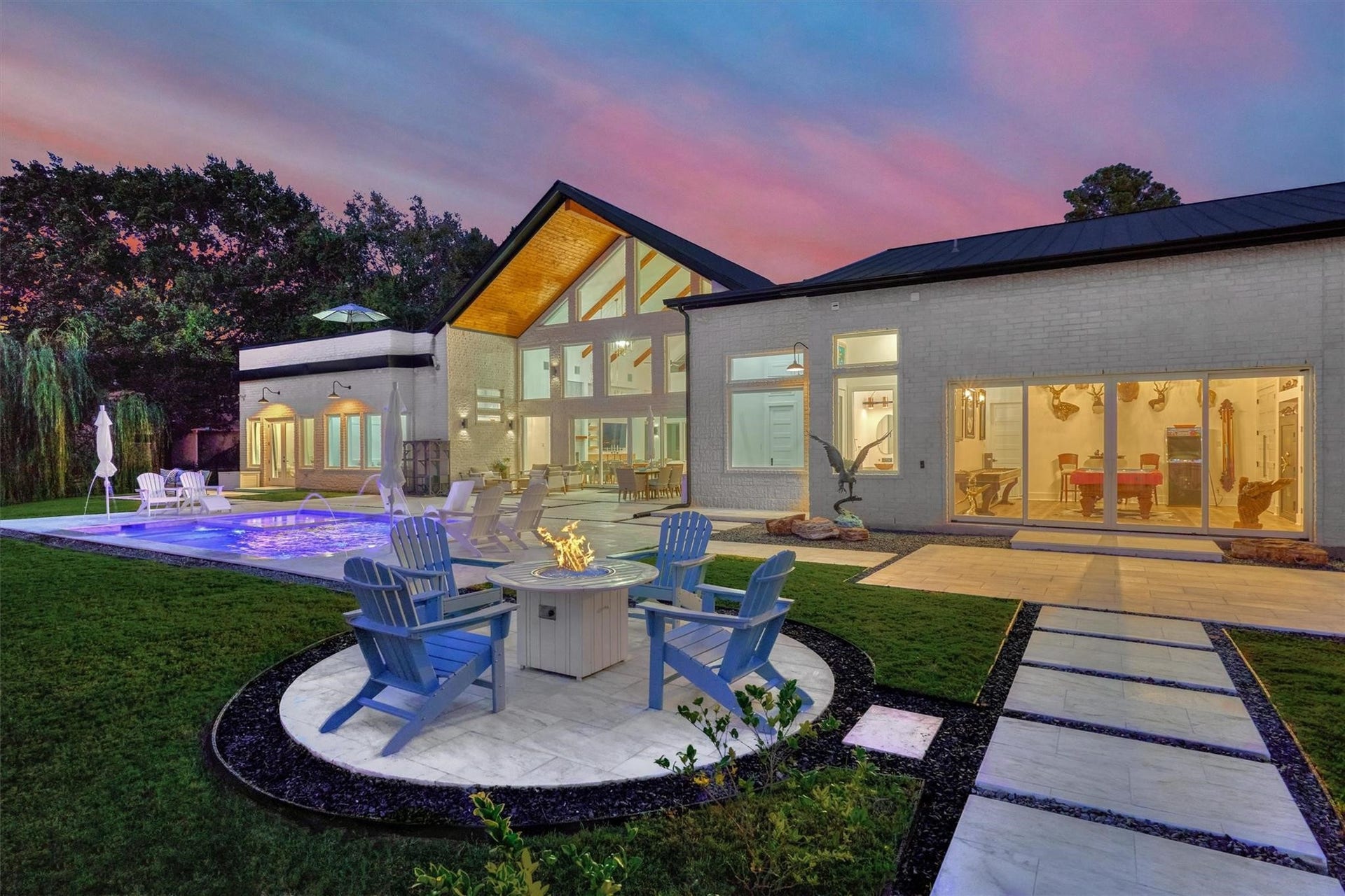 9228 Lake Conroe Drive, Conroe, TX 77304 6. Enjoy cooler evenings, lake front, around the gas firepit.
7. Accent lighting along the back of the home enhances visibility in the evening, adding a beautiful glow to the home's unique and striking design. Expansive marble patio areas offer opportunity for multiple seating and entertaining spaces.