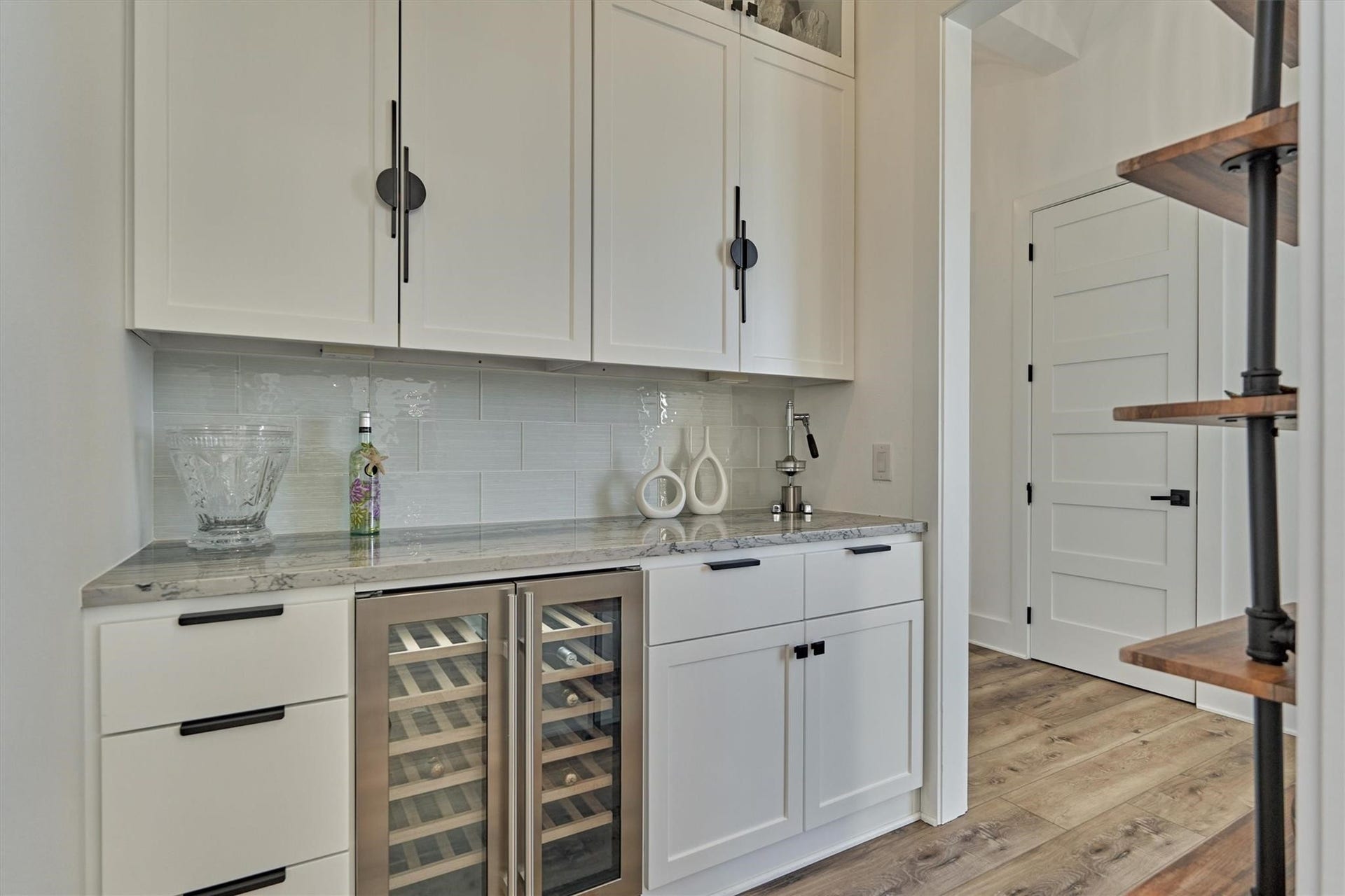 9228 Lake Conroe Drive, Conroe, TX 77304 This stylish beverage bar, off of the kitchen, is complete with a wine refrigerator and custom cabinetry. Extra detail was taken in this space with unique upper cabinet hardware and industrial style shelving on the opposite wall.