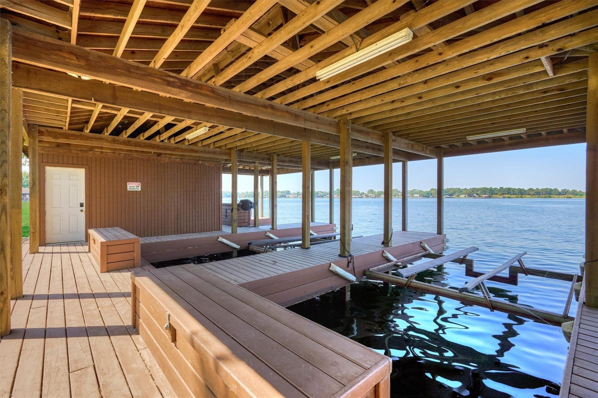 9228 Lake Conroe Drive, Conroe, TX 77304 47. The oversized boathouse features two boat lifts, two jet ski lifts, a fish cleaning station, and a spacious storage closet, offering everything you need for lakefront convenience and outdoor recreation.
