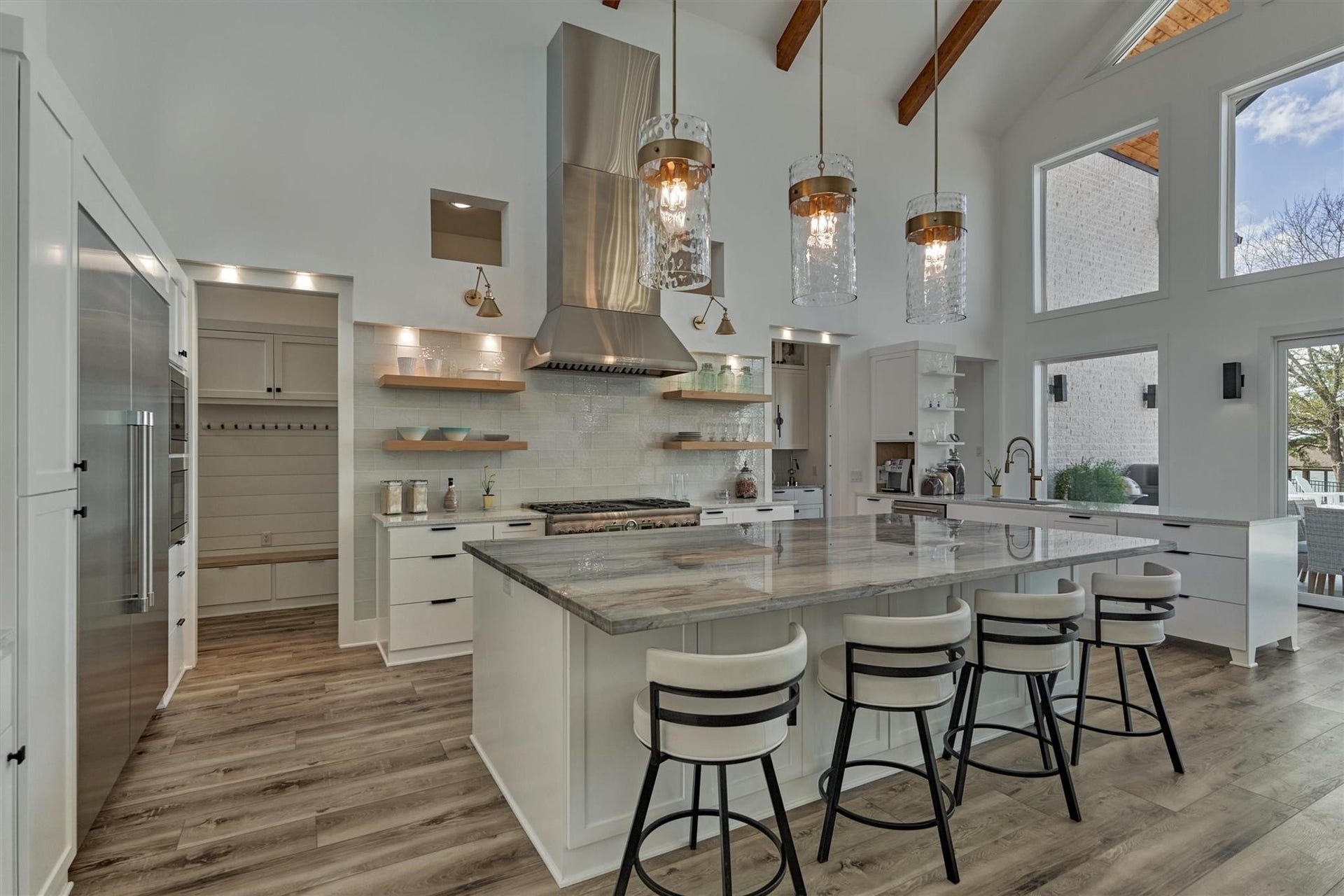 9228 Lake Conroe Drive, Conroe, TX 77304 A solid piece of quartzite tops the island which features hidden storage on the seating side. Wave inspired glass pendant lighting adds a striking focal point in the space.