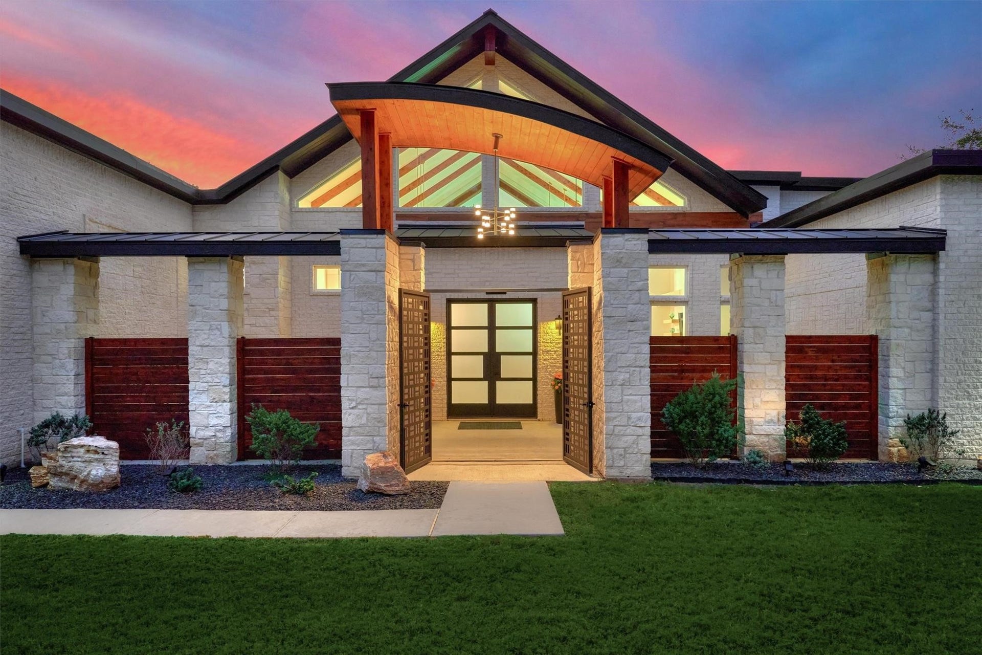 9228 Lake Conroe Drive, Conroe, TX 77304 10. A custom iron gate opens to the private courtyard, leading the way to the front entry doors.
11. Opaque glass on the custom metal doors offers privacy while allowing natural light to filter in. River rock flanks both sides of the entry sidewalk in the courtyard, adding rich texture and enhancing the overall aesthetic of the space.