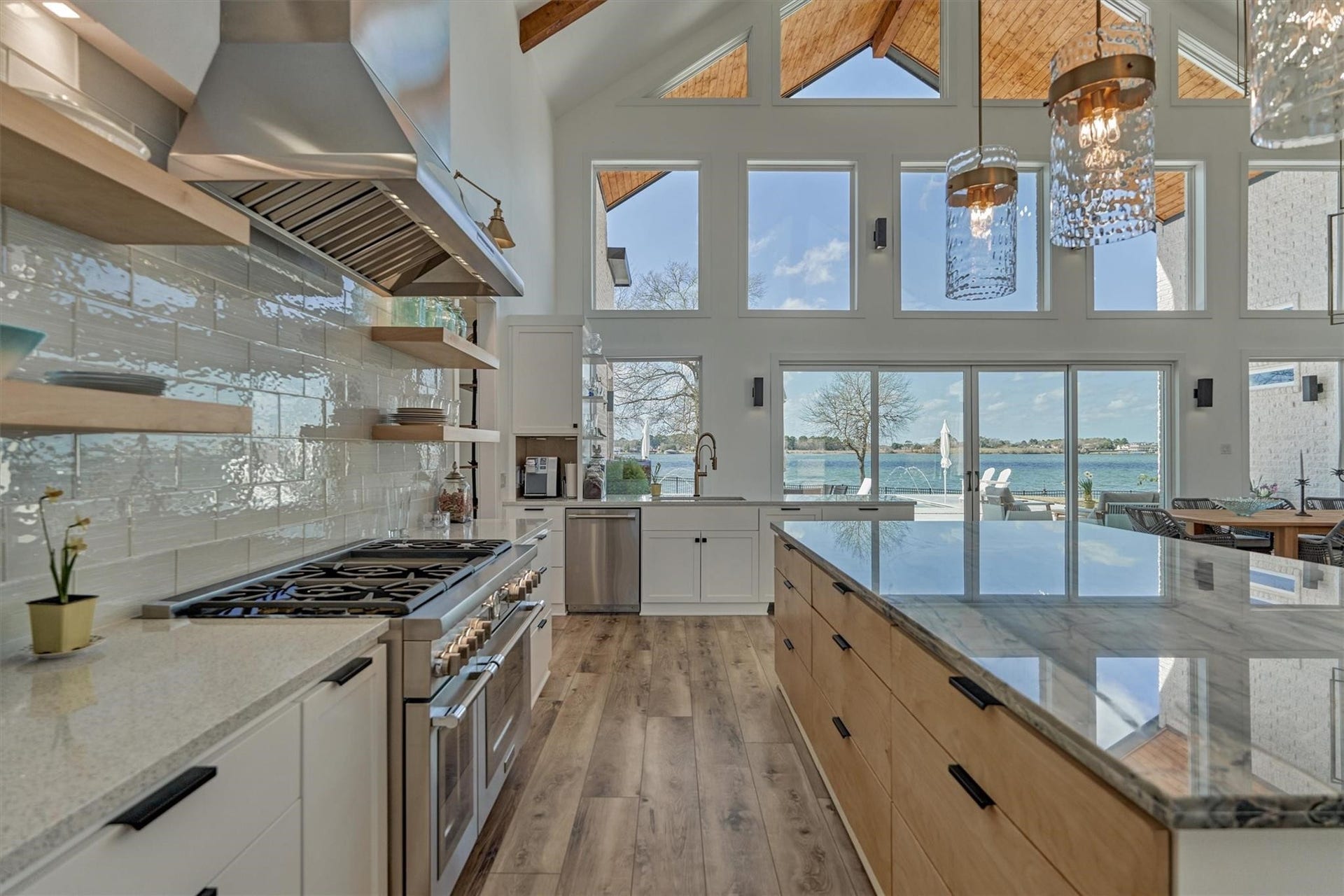 9228 Lake Conroe Drive, Conroe, TX 77304 A Thermador stove with double ovens, 6 burners and a griddle is flanked on either side with custom spice and utensil drawers.