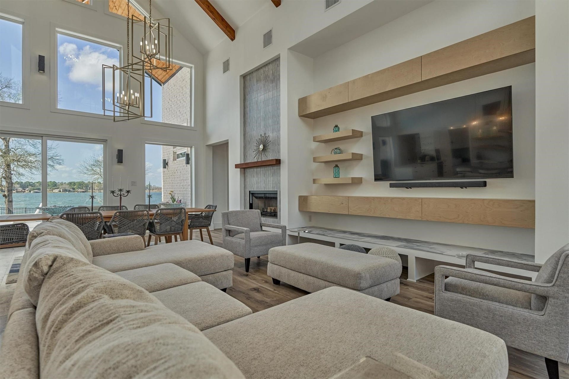 9228 Lake Conroe Drive, Conroe, TX 77304 The living area features modern style built-ins that not only provide ample storage but also create a dedicated space for the TV and electronics, adding both functionality and style to the room. Beneath the television, the wood "beam" is actually a cleverly designed row of storage drawers blending with the modern aesthetic while offering functional storage.