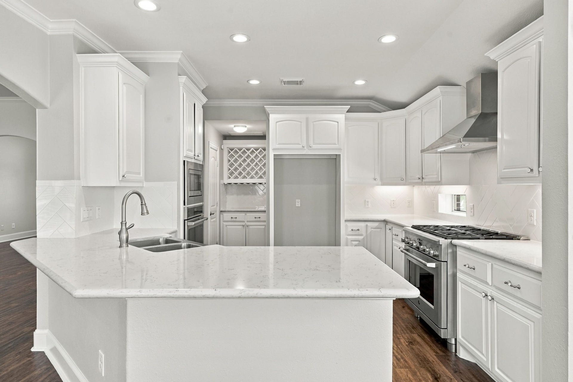 33211 Woodton Court, Fulshear, TX 77441 This view showcases the entire Kitchen and all of its beautiful features, from the stylish finishes to the thoughtfully designed layout. In the distance, you can catch a glimpse of the Butlers Pantry, offering the perfect space for storing and displaying your favorite wine, serving pieces, and additional kitchen essentials.