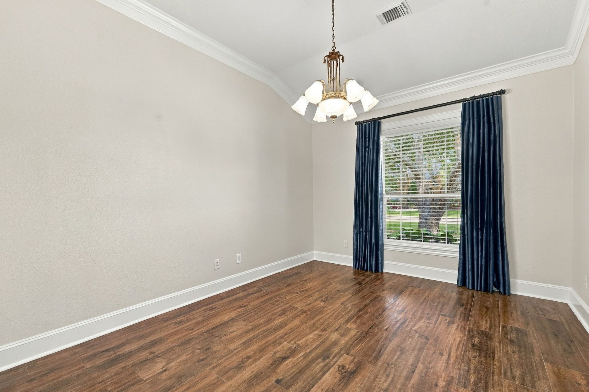 33211 Woodton Court, Fulshear, TX 77441 The Formal Dining area is located just off the Foyer and features elegant silk window drapes, a large picturesque window, beautiful wood-look tile flooring, and an elegant chandelier, creating a warm and sophisticated setting for entertaining and special occasions.