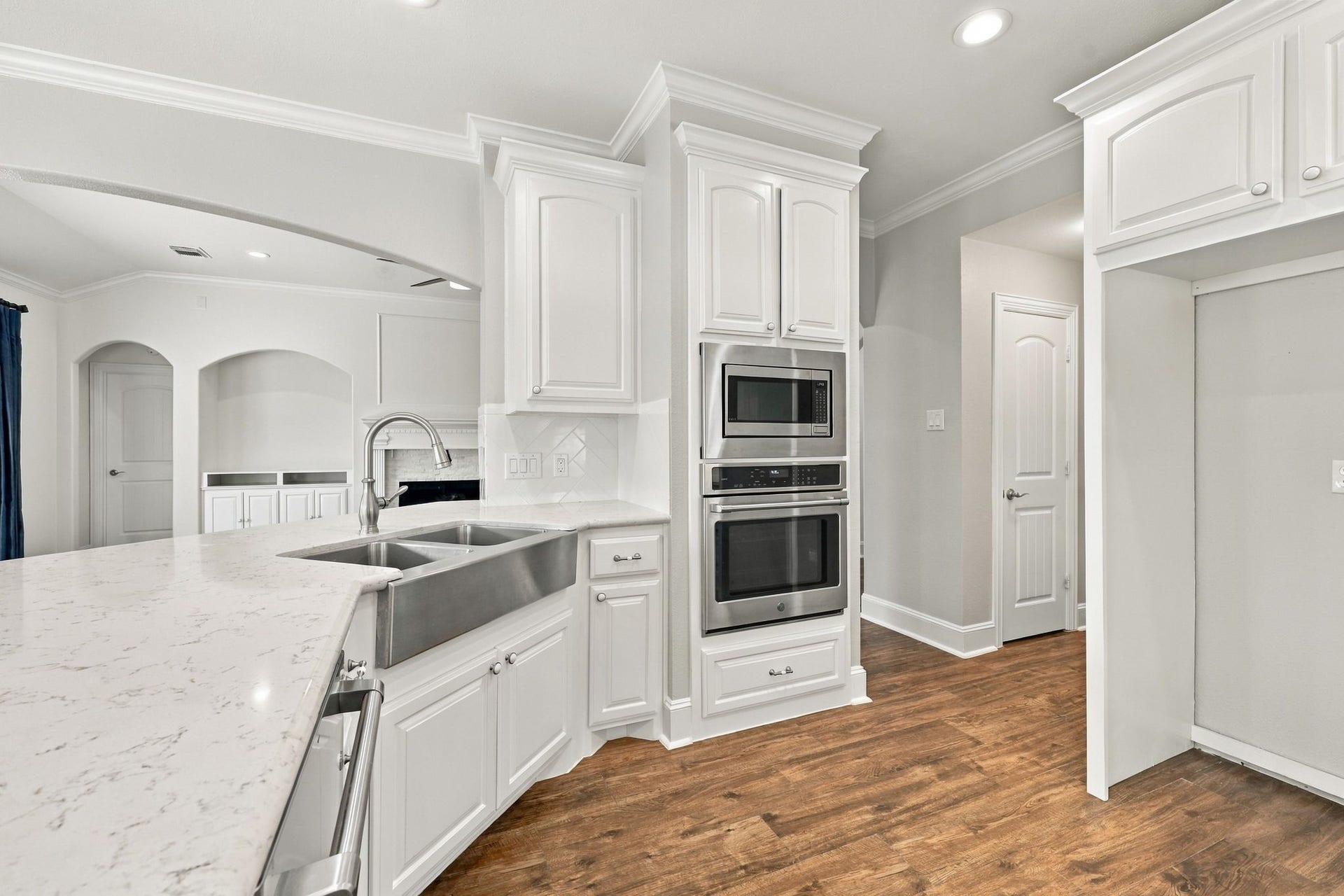 33211 Woodton Court, Fulshear, TX 77441 The refrigerator space is beautifully framed in for a polished, built-in look, while the door to the left leads to the spacious pantry, providing convenient access to additional storage.
