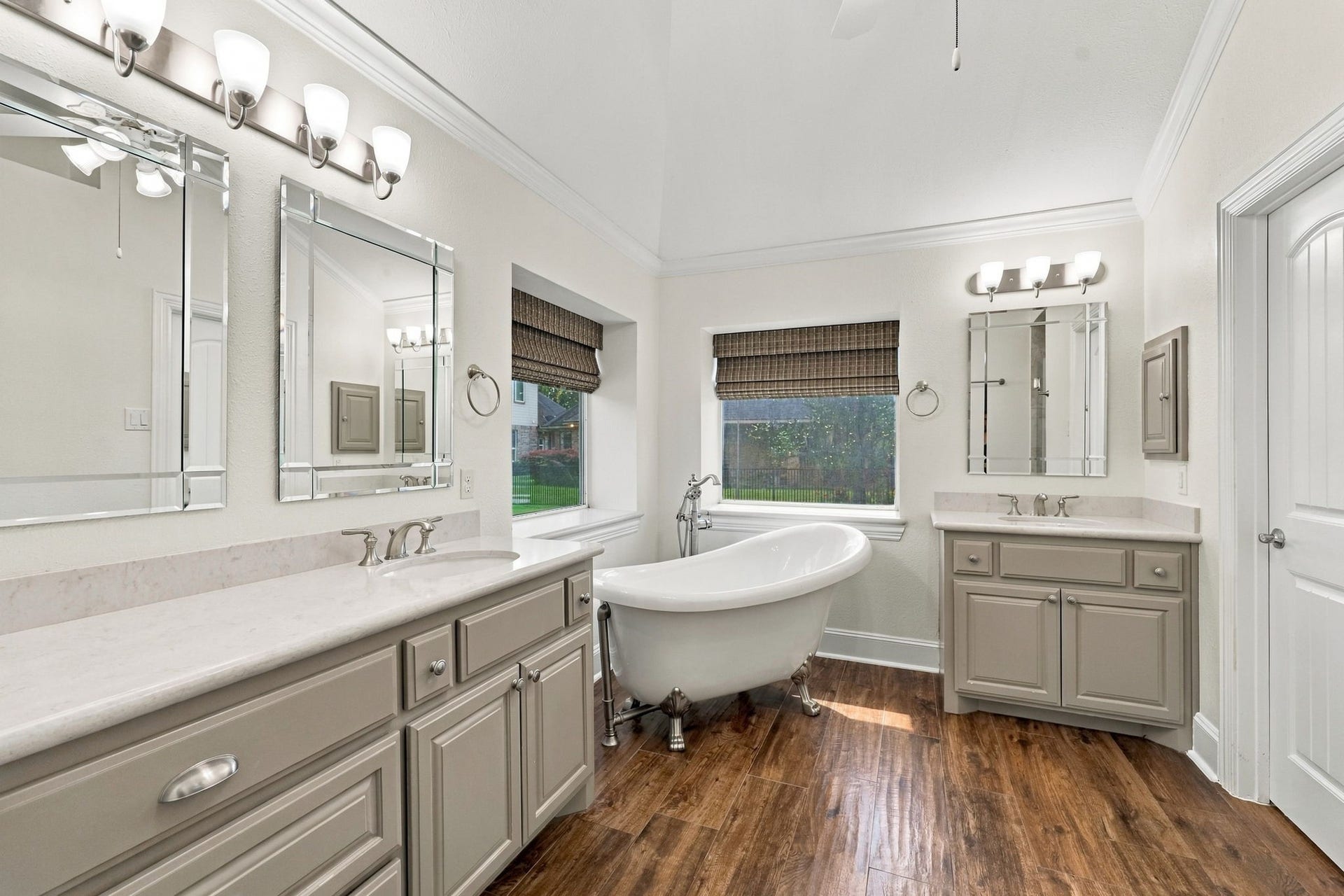 33211 Woodton Court, Fulshear, TX 77441 The Primary Bath is luxurious and beautifully appointed with wood-look tile flooring, dual vanities featuring beautifully painted accent cabinetry and drawers, medicine cabinets, beveled mirrors, a stunning freestanding clawfoot soaking tub, and gorgeous Quartz countertops. Thoughtfully designed finishes create a relaxing and sophisticated retreat.