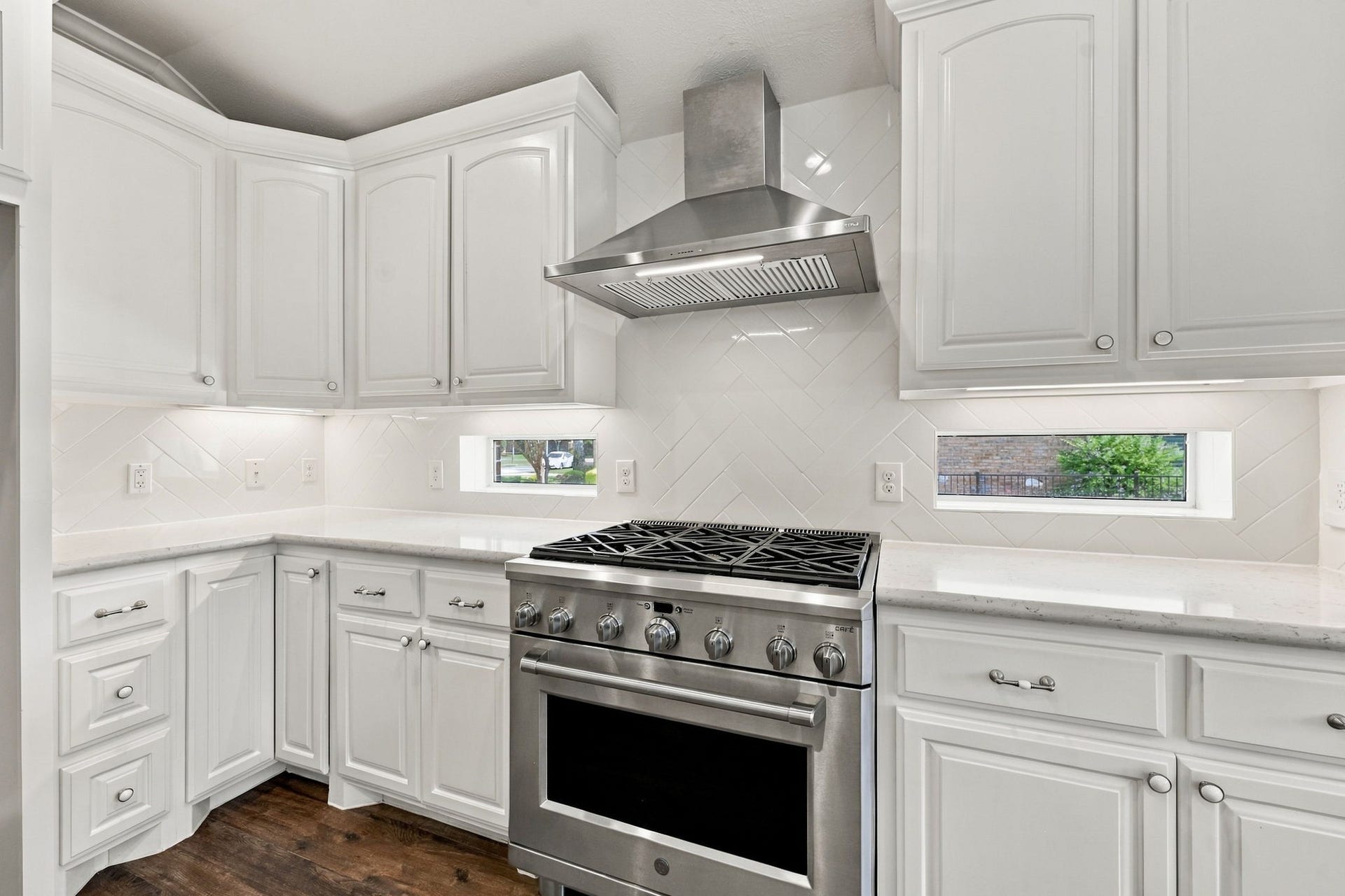 33211 Woodton Court, Fulshear, TX 77441 The commercial-grade GE Caf 6-burner gas range with electric oven is a chefs dream, complemented by a sleek stainless steel vent hood above. Two elegant windows on either side fill the space with natural light, while the gorgeous subway tile backsplash, beautifully set in a herringbone pattern, adds a stylish finishing touch.