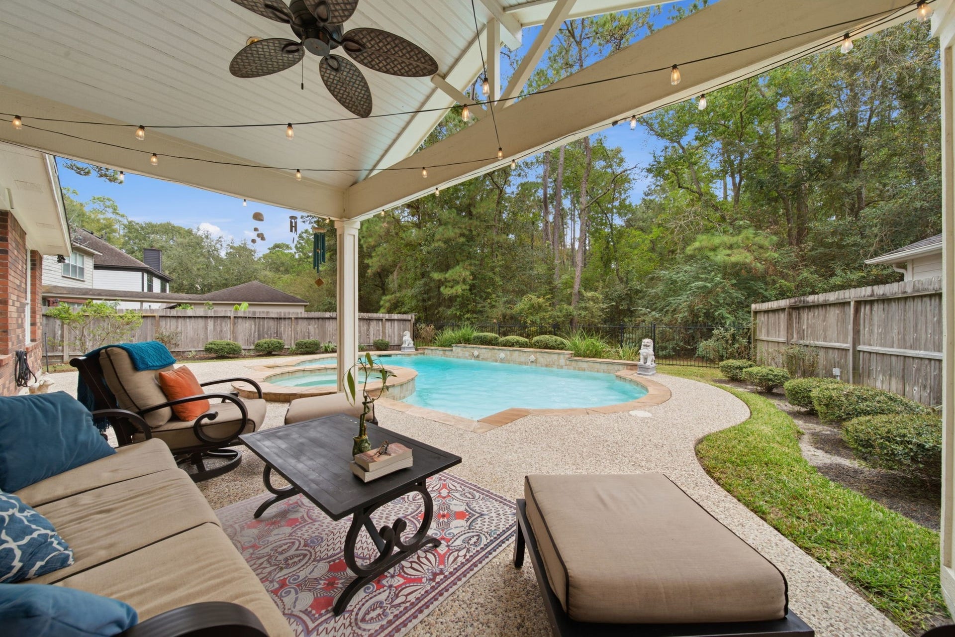 99 E Sterling Pond Circle, The Woodlands, TX 77382 A fantastic addition to the home, this spacious covered patio offers an inviting spot to relax or entertain, overlooking the modern designed pool & spa. A vaulted ceiling, ceiling fan, and string lighting create a fun setting, especially at night. The wrought iron fencing along the back preserves the wooded views. This is a wonderful place to enjoy morning coffee or evening wine-down while you enjoy watching nature put on a show.