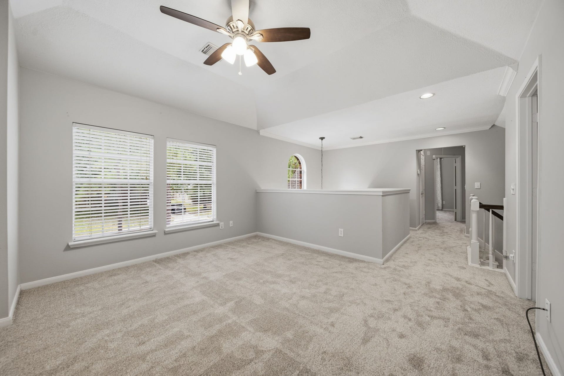 99 E Sterling Pond Circle, The Woodlands, TX 77382 The upstairs game room offers a versatile space for games, movie nights, toys, or a second living area. High ceiling, neutral decor, and two large windows create a bright, open feel, while a ceiling fan adds comfort to this inviting gathering space.