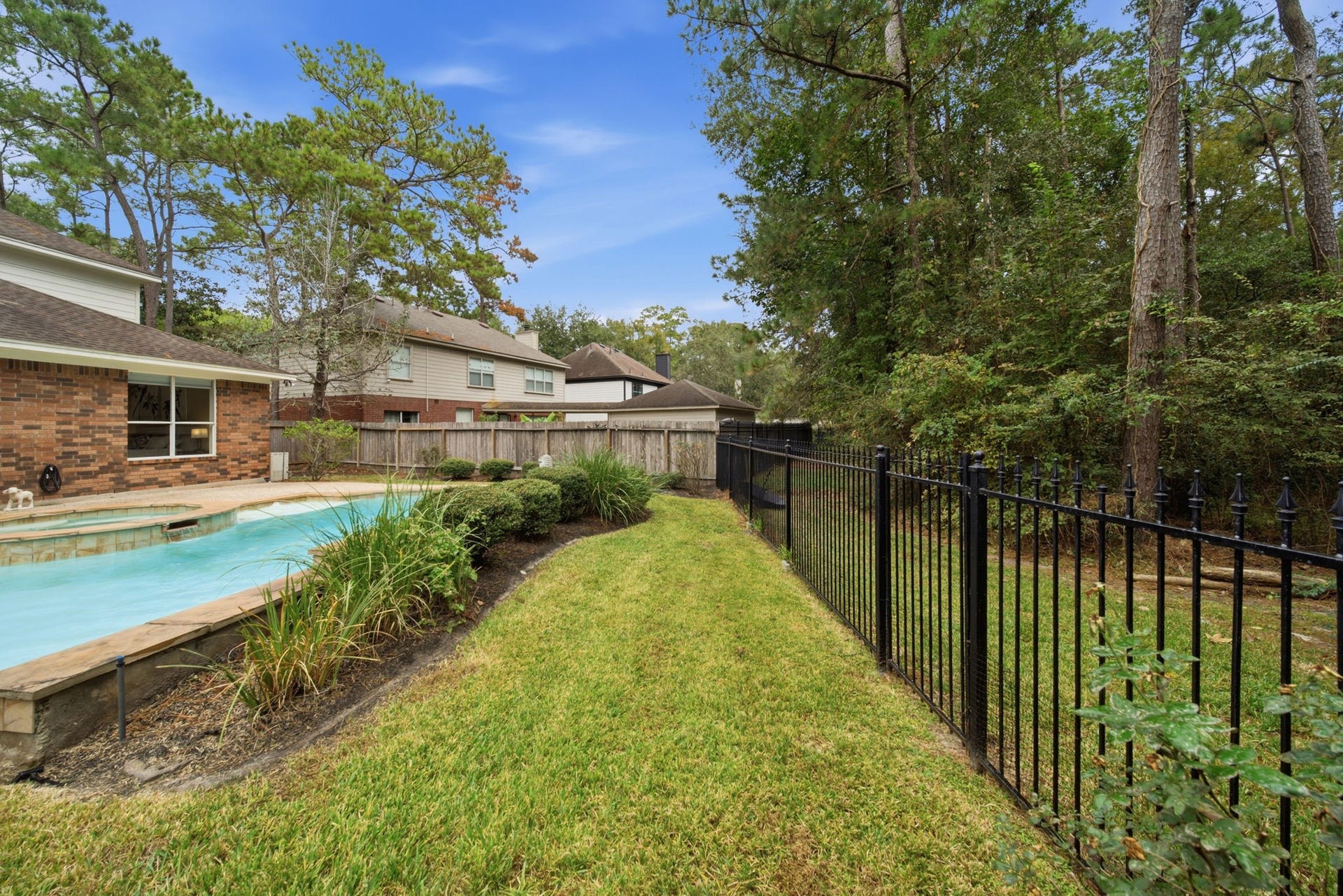 99 E Sterling Pond Circle, The Woodlands, TX 77382 Enjoy peaceful wooded views through the wrought iron fence in this inviting back yard. The sparkling pool, landscaped beds, and grassy areas create a beautiful setting for outdoor relaxation and watching nature.