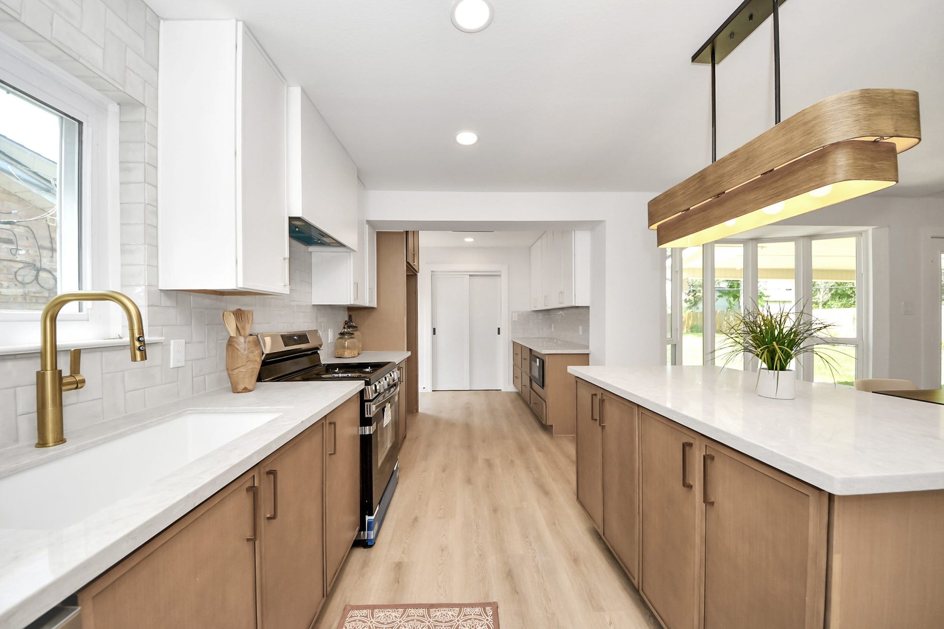 5946 Willowbend Boulevard, Houston, TX 77096 Modern chefs kitchen featuring quartz countertops, new cabinetry, designer hardware, and oversized island with waterfall detail.