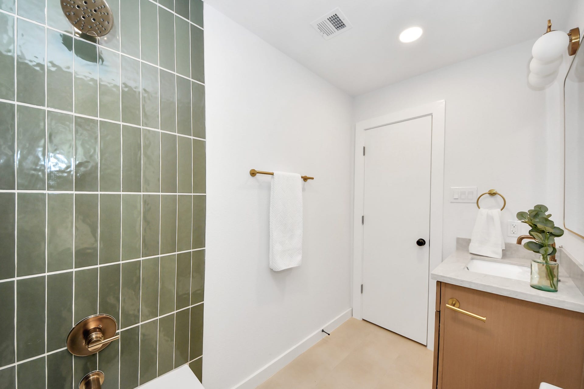 5946 Willowbend Boulevard, Houston, TX 77096 Beautiful secondary bathroom with custom vanity, modern fixtures, and striking designer tile details.