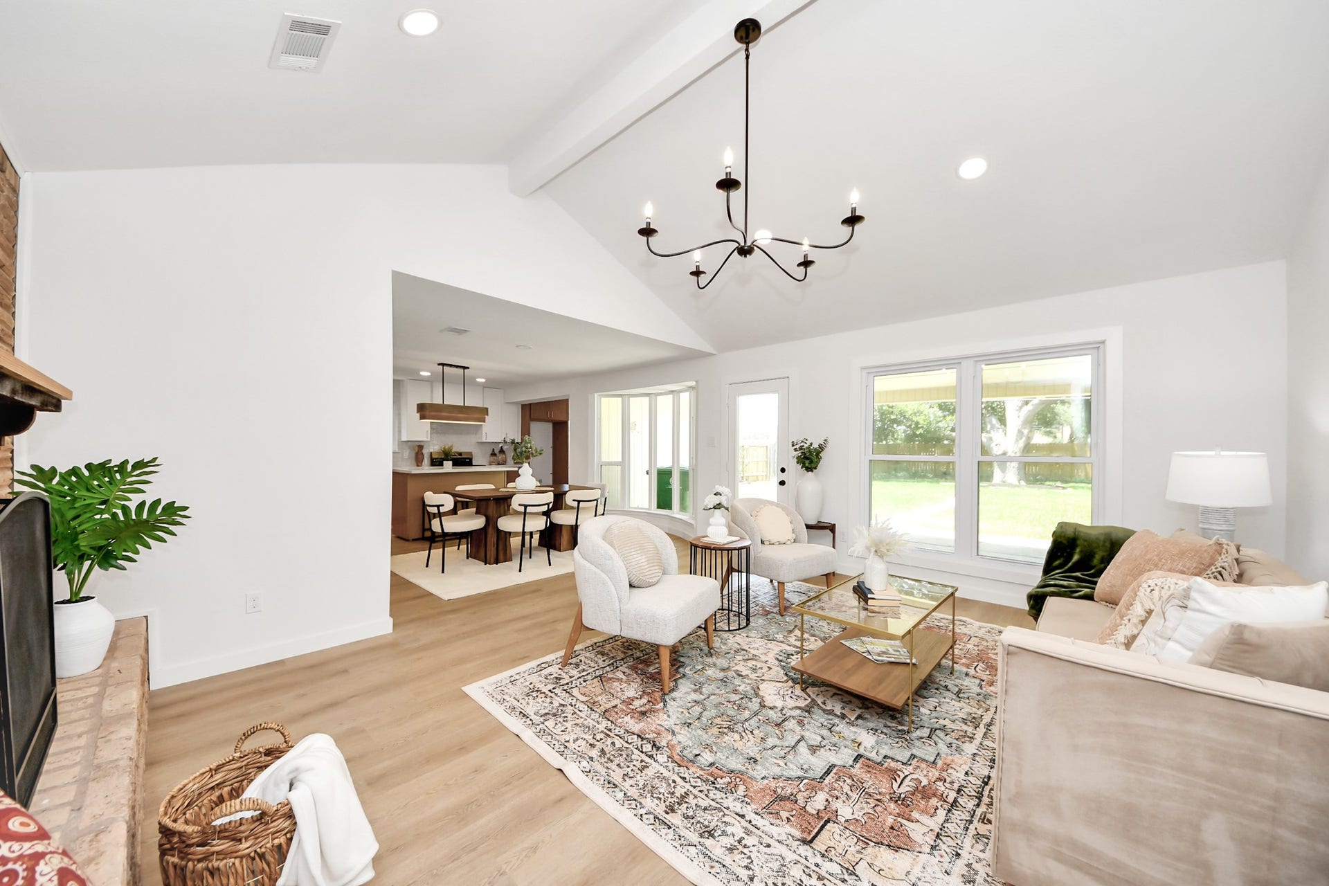 5946 Willowbend Boulevard, Houston, TX 77096 Expansive living room filled with natural light, featuring vaulted ceilings, designer chandelier, and curated finishes.