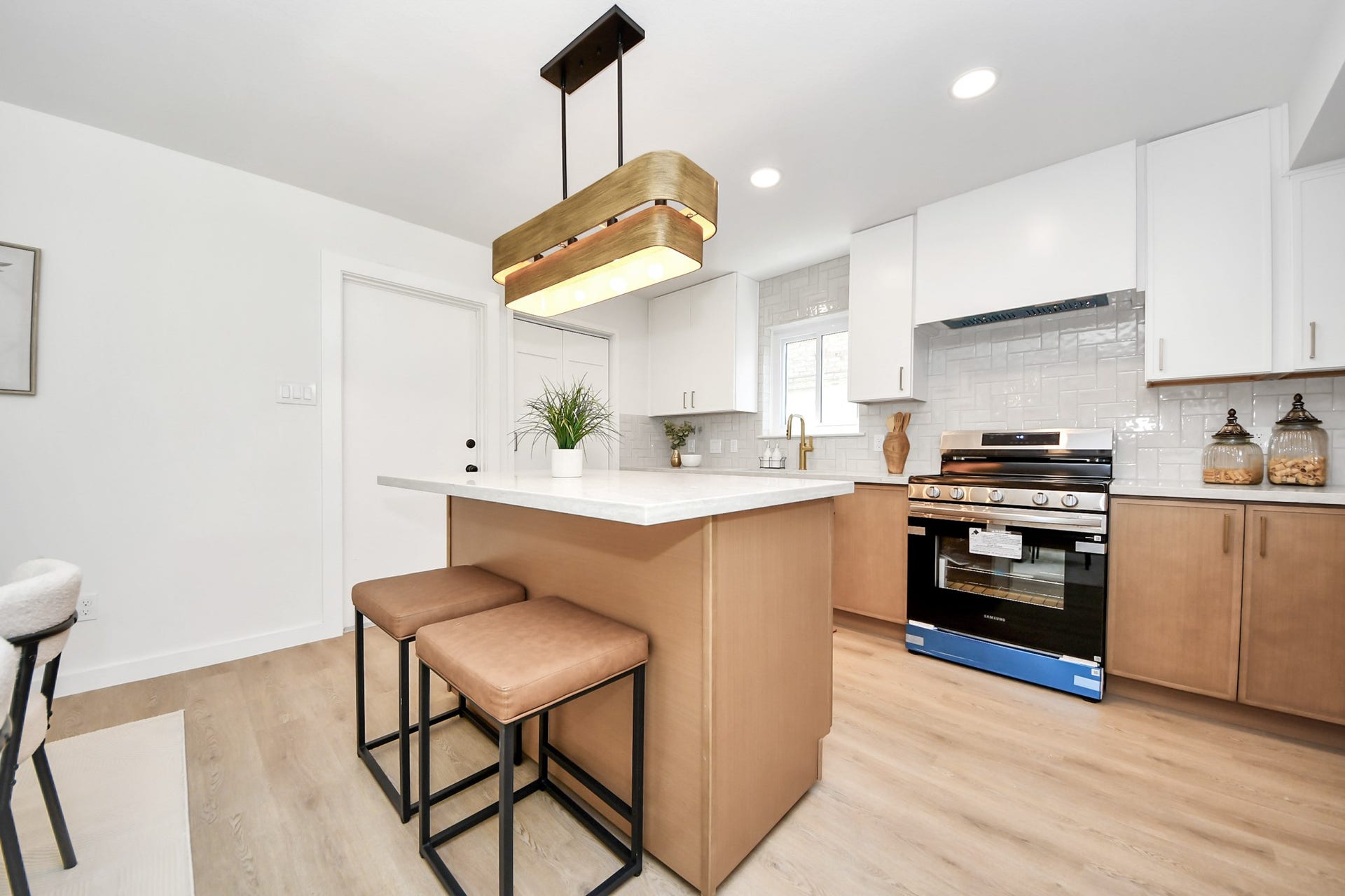 5946 Willowbend Boulevard, Houston, TX 77096 Modern open kitchen with oversized island, designer pendant lighting, stainless steel appliances, and new cabinetry.